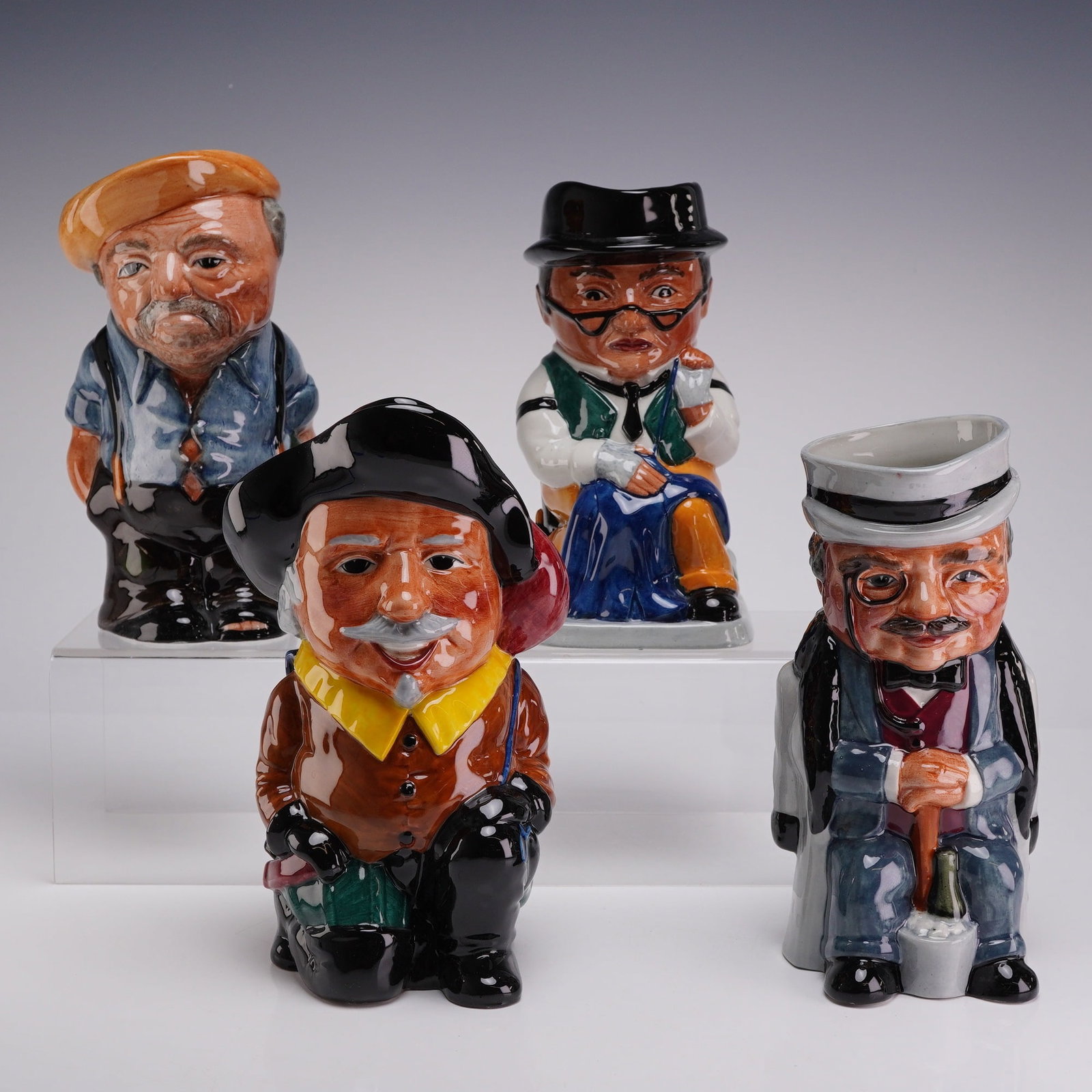 4pc Staffordshire Fine Ceramics Hand Painted Toby Jugs: This group consists of four glazed earthenware character jugs manufactured by Staffordshire Fine Ceramics in England. Each jug is modeled as a specific character with hand-painted polychrome decoratio