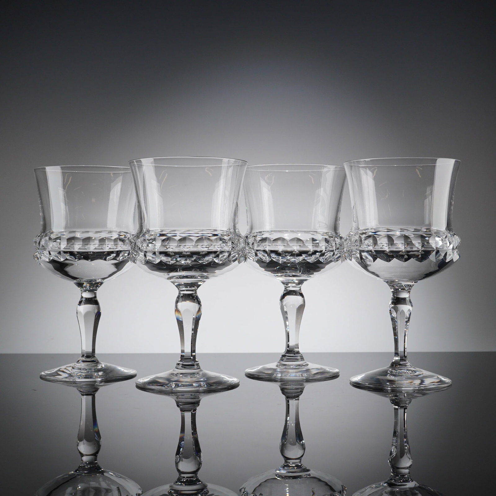A Collection of 4 Orrefors Silvia Cut Crystal Claret Wine Glasses: A collection of 4 Orrefors Crystal glasses in the 'Silvia' patern, featuring clear colorless cut crystal construction. Each stemmed glass presents a relatively straight-sided, deep bowl distinguished 