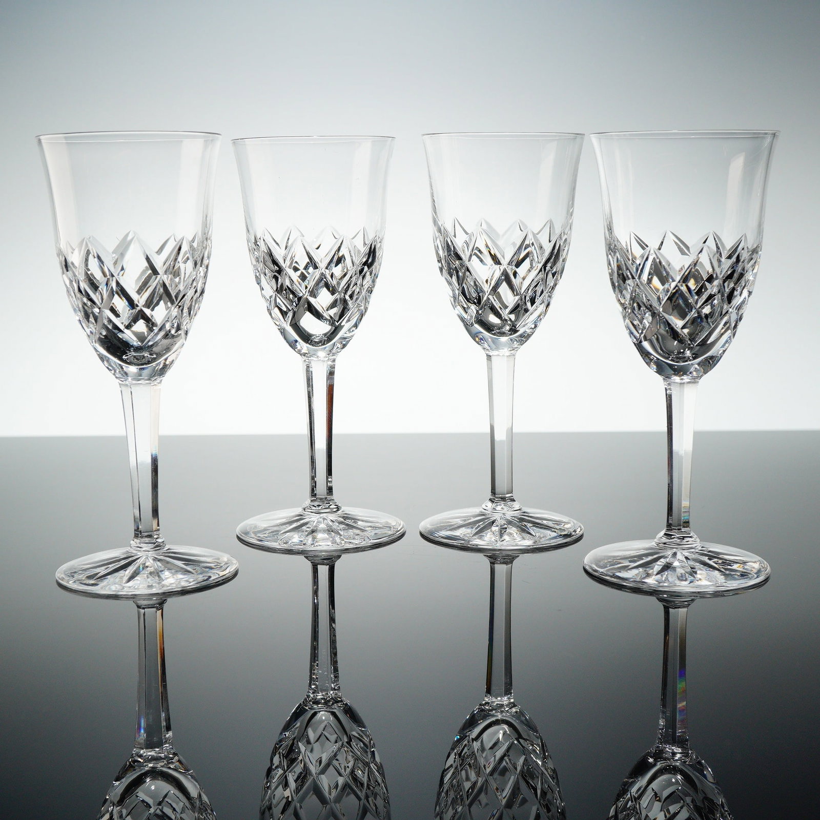 Set of Four Orrefors Cut Crystal Stemware Sherry Glasses: A set of four matching stemmed glasses crafted from clear, colorless, highly refractive cut crystal. These items are designed for use as sherry or cordial glasses, consistent with market descriptions 