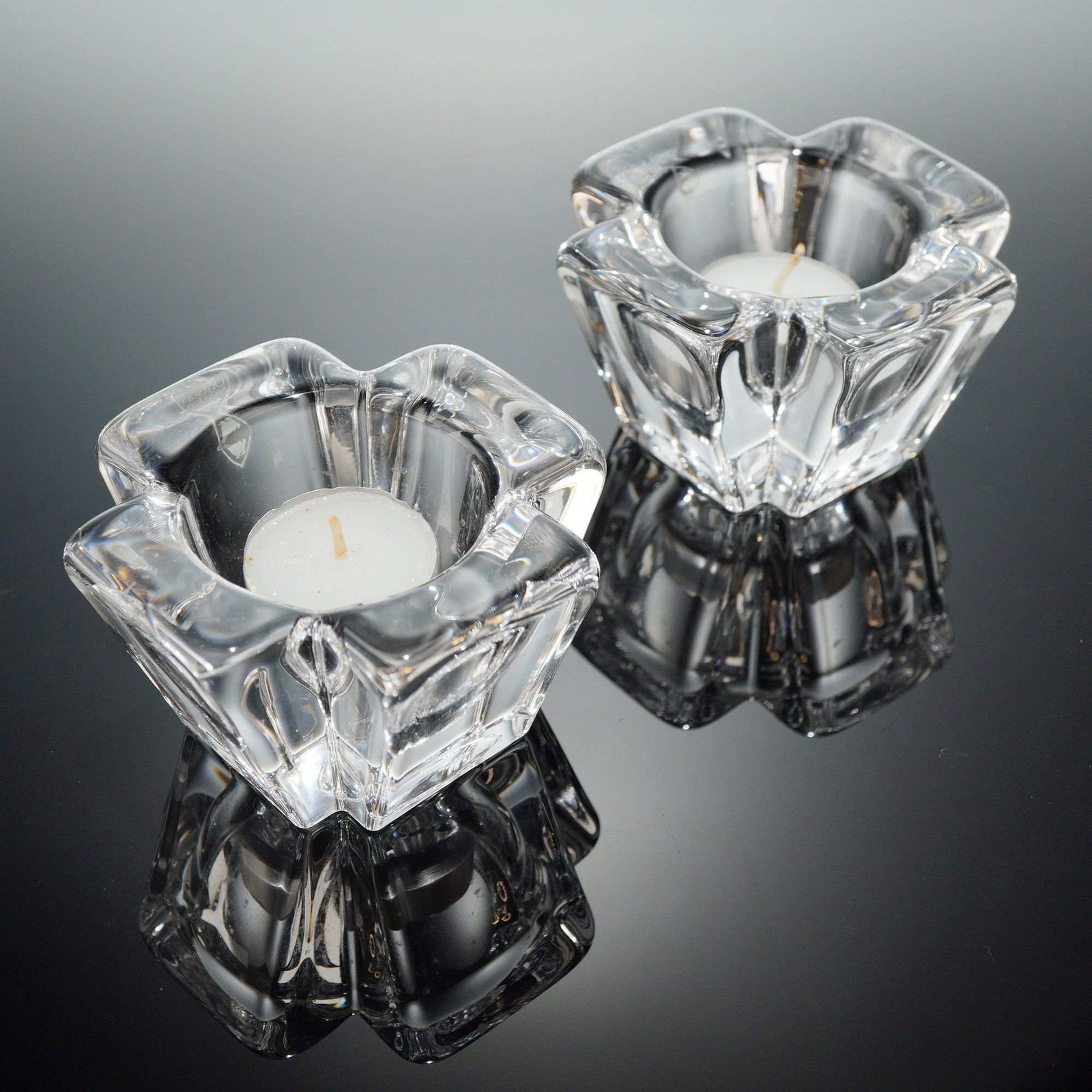 A Pair of Orrefors MAX Crystal Votive Candle Holders: A pair of Orrefors crystal candle holders, identifi?ed through web consensus as the MAX patern, often atributed to designer Anna Ehrner. These 2pc crystal candle holders are crafted from heavy clear g