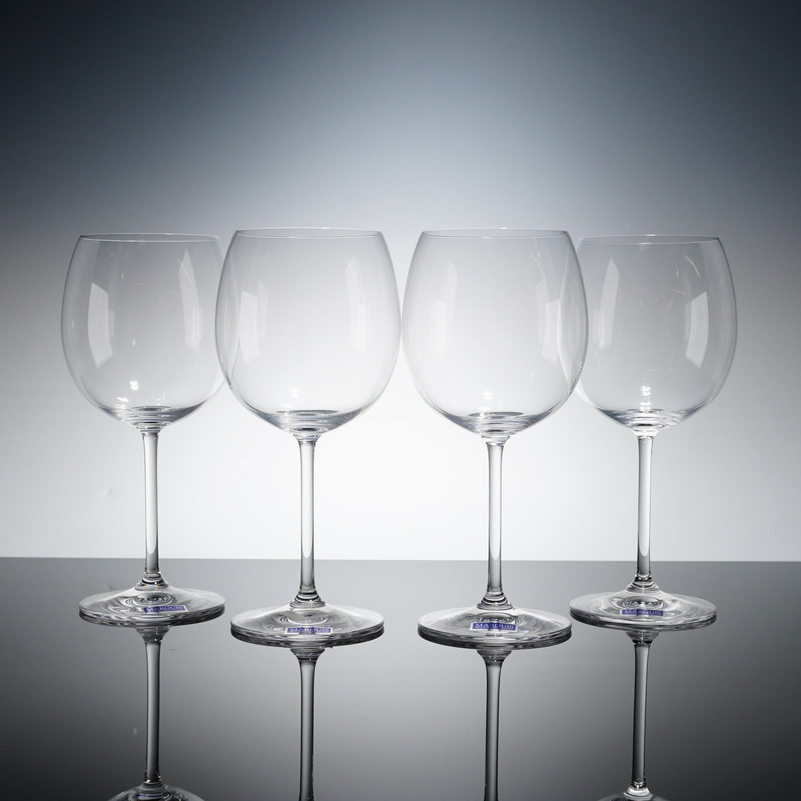 Set of 4 Marquis by Waterford Crystal Glasses, Vintage Light Red Wine: Each clear crystal glass is constructed with a large, rounded bowl, a slender stem, and a circular foot. The bases are acid-etched with the MARQUIS BY Waterford mark. Original blue and silver manufact