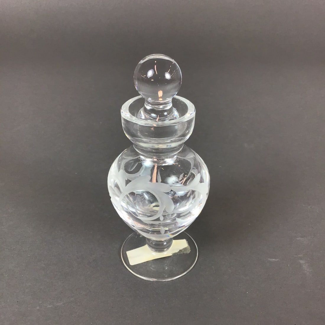 Marquis by Waterford Etched Crystal Perfume Bottle with Stopper, Yours Truly: The vessel features a bulbous, globular body decorated with an etched floral and scrollwork design. It is set upon a short stem with a circular footed base and terminates in a flared rim. The piece in