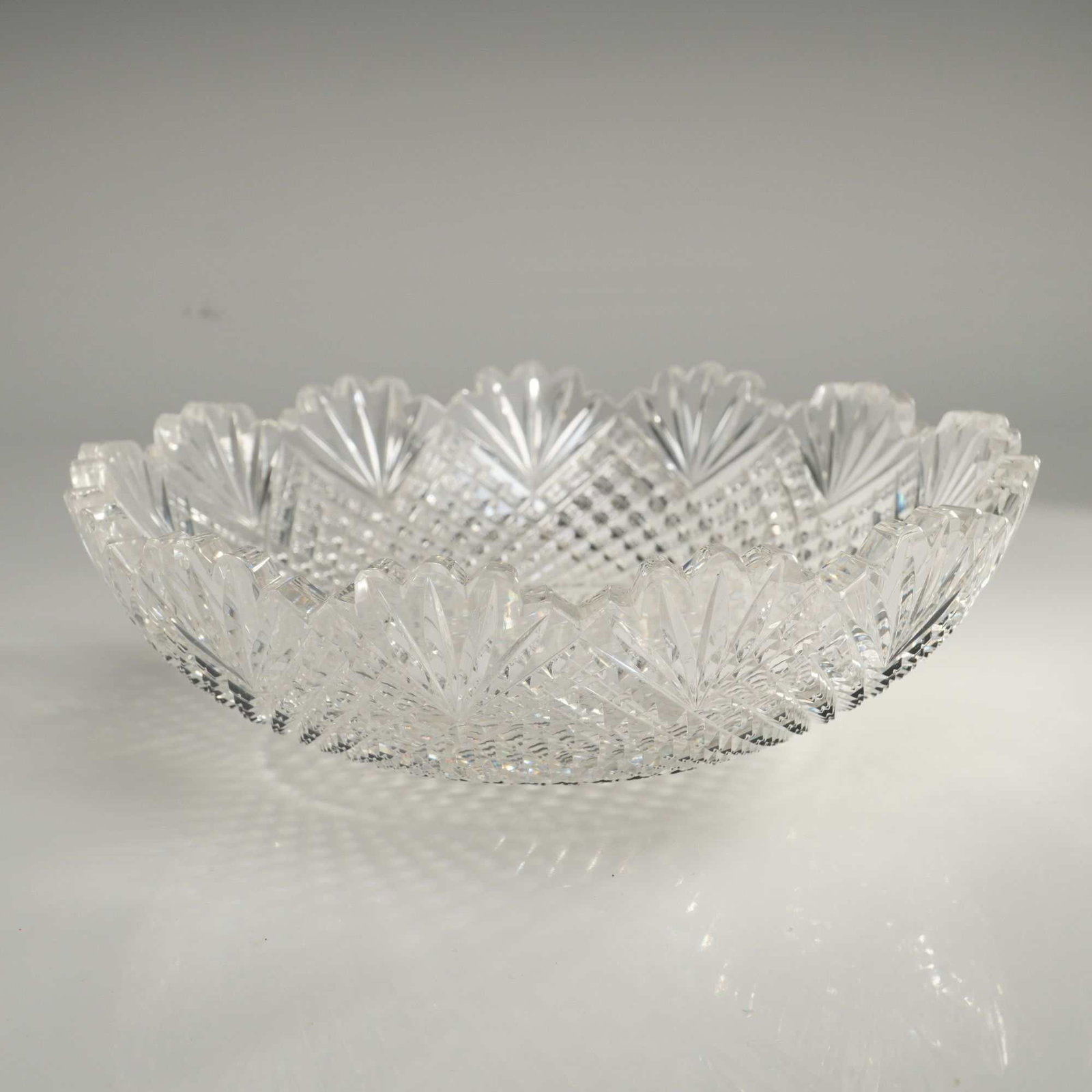 American Brilliant Period Cut Glass Bowl in the Strawberry Diamond and Fan Pattern: This American Brilliant Period (ABP) cut glass bowl is decorated in the Strawberry Diamond and Fan pattern. The object is crafted from heavy lead crystal featuring deep-cut geometric ornamentation. Th