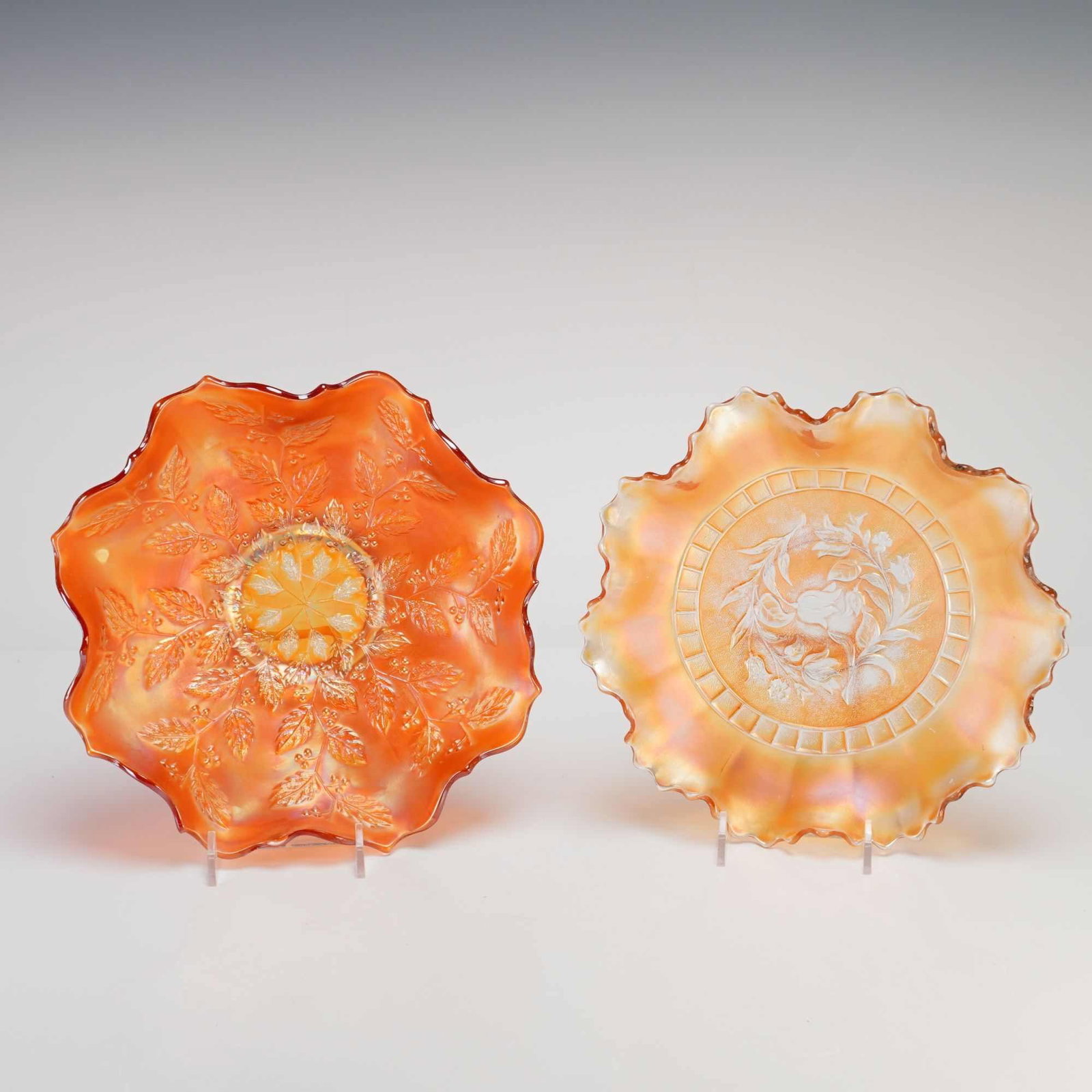 Two Marigold Carnival Glass Ruffled Bowls, Fenton Holly and Imperial Rose Patterns: This lot features two pieces of American carnival glass showcasing classic patterns from the early to mid-20th century. The first item is a pressed glass bowl in the marigold colorway, attributed to t