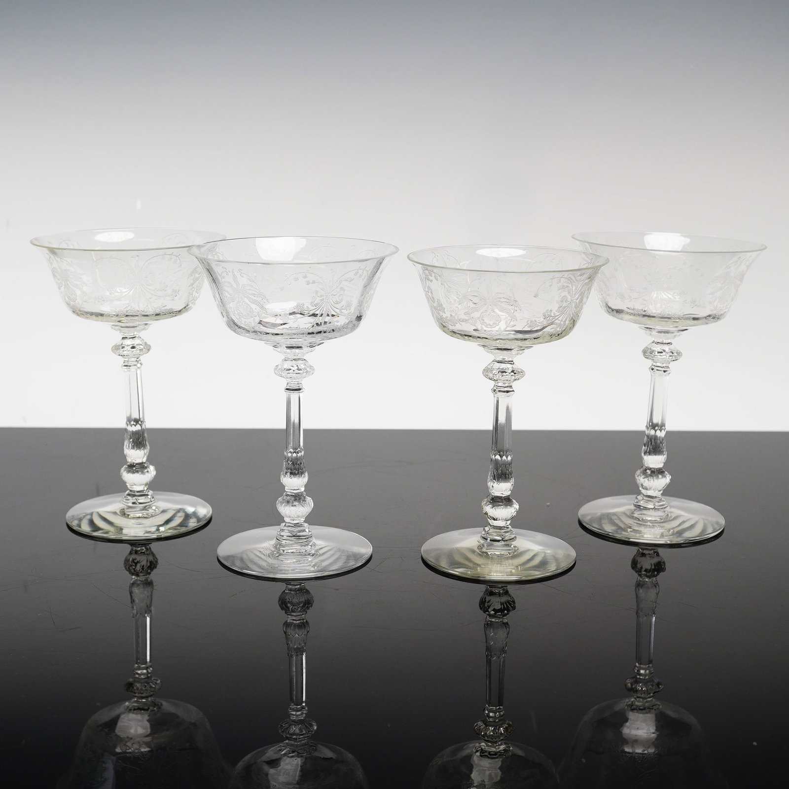 4pc Heisey Orchid Pattern Etched Crystal Champagne Coupes: This set of champagne coupes features the Orchid pattern by Heisey, a prominent example of American Elegant Glass from the mid-20th century. Each glass is constructed from colorless crystal with high 