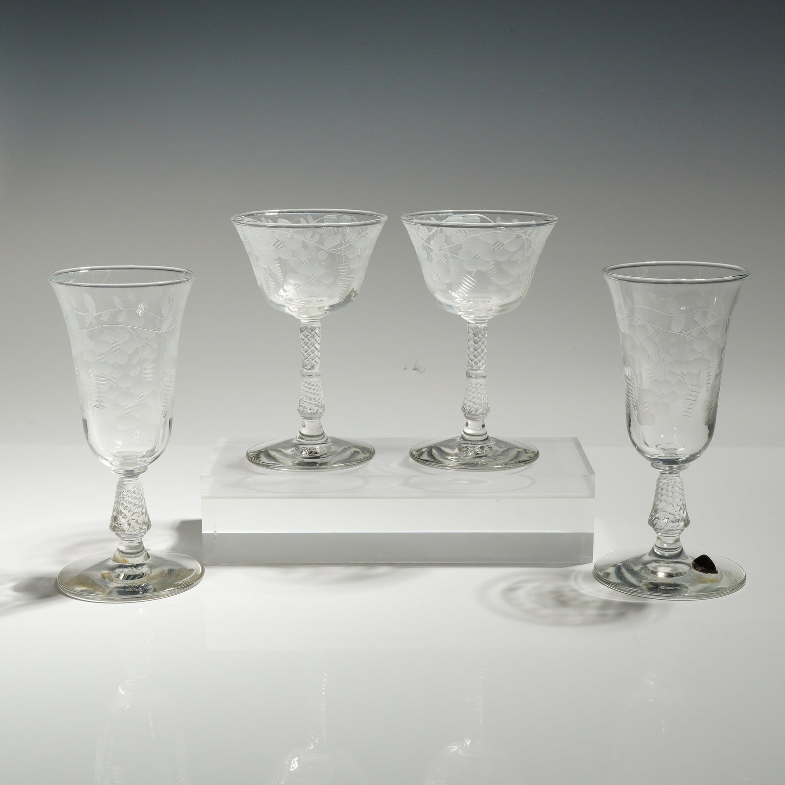 4pc Rock Sharpe Crystal Floral Etched Juice and Liquor Glasses: The set consists of two distinct pairs: two short-stemmed juice glasses and two taller liquor/cocktail glasses with smaller bowls. Each piece features a delicate neoclassical wheel-etched pattern of t