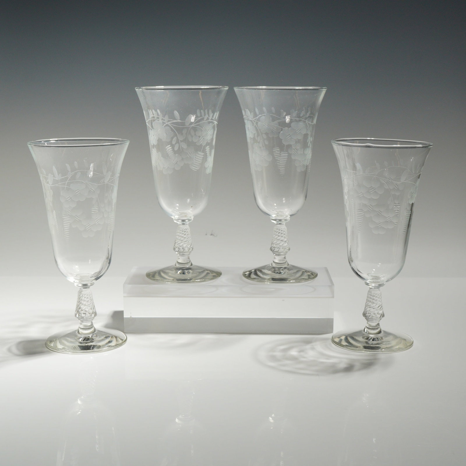 4pc Rock Sharpe Crystal Floral Etched Iced Tea Glasses: Each vessel features a flared, trumpet-shaped bowl decorated with a delicate, continuous wheel-engraved band depicting a trailing vine of hops and stylized floral blossoms. The bowls are supported by 