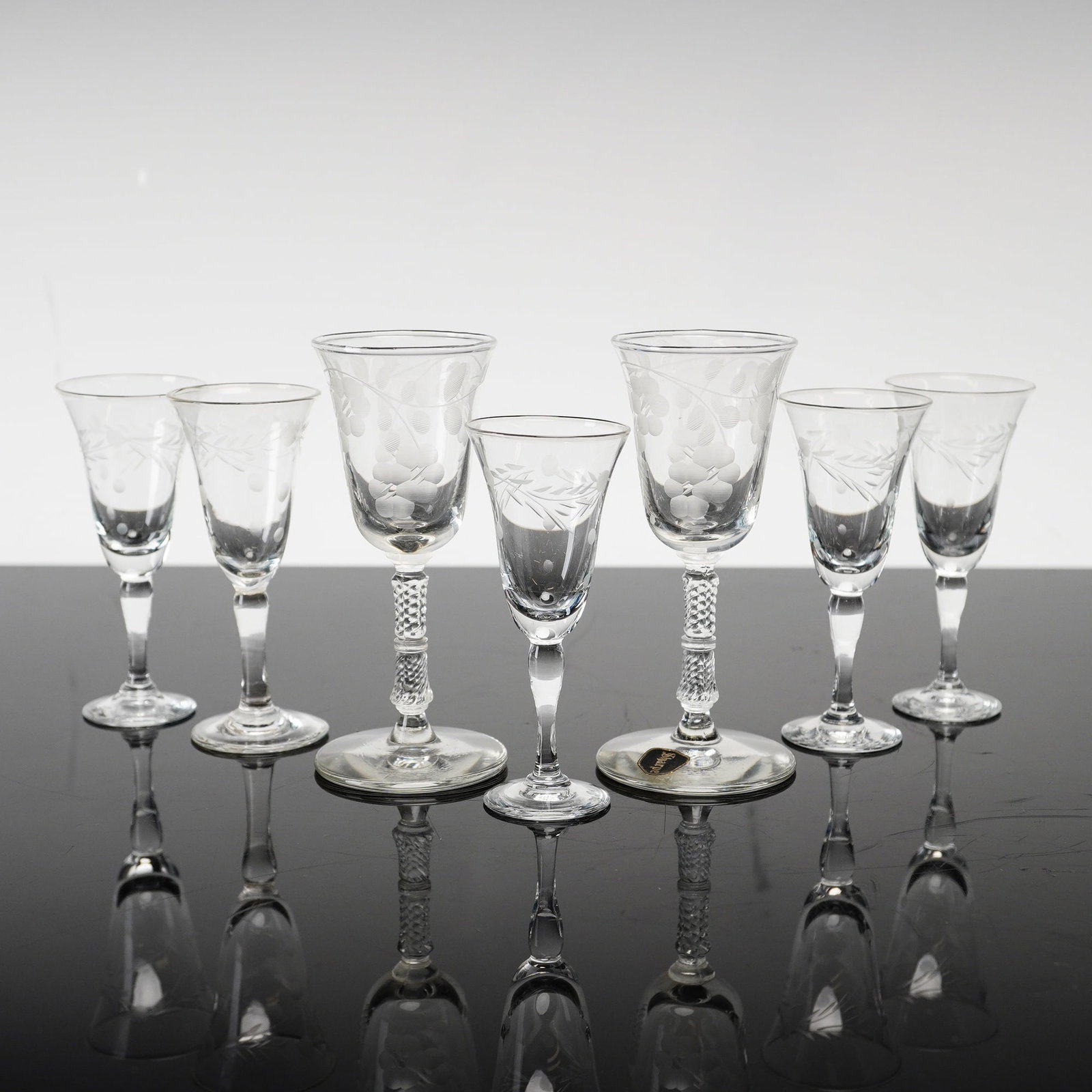 7pc Sharpe Etched Glass Stemware Pieces: A set of 7 glasses by the Sharpe company of Buffalo, New York. The collection includes two distinct sizes of stemware: five smaller cordial or liqueur glasses and two larger glasses suitable for