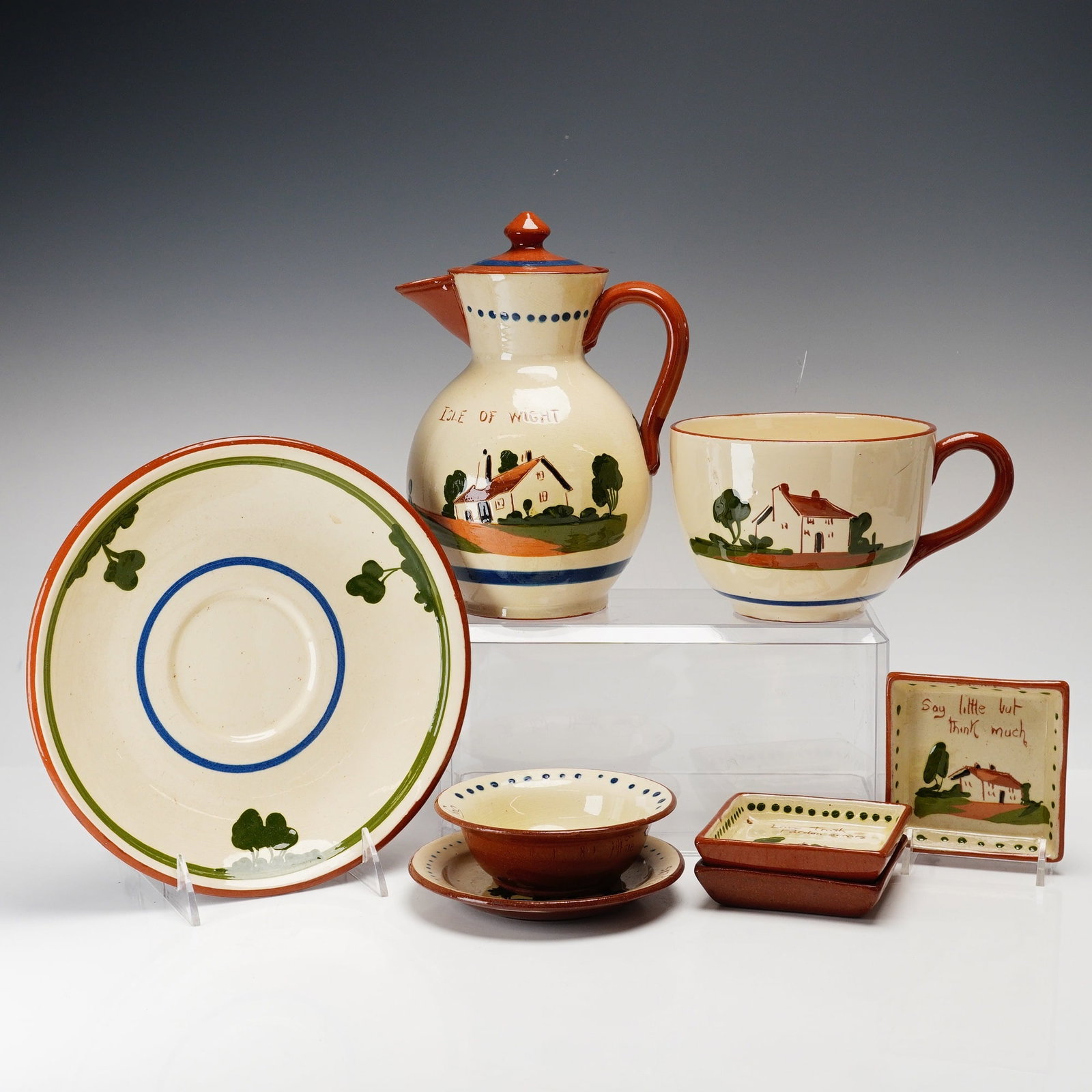 8pc Torquay Pottery Motto Ceramic Ware: This set of 8 Torquay Pottery motto ware ceramic items is comprised of various souvenir pieces produced in the Devon region of England. The collection includes red earthenware vessels and dishes featu