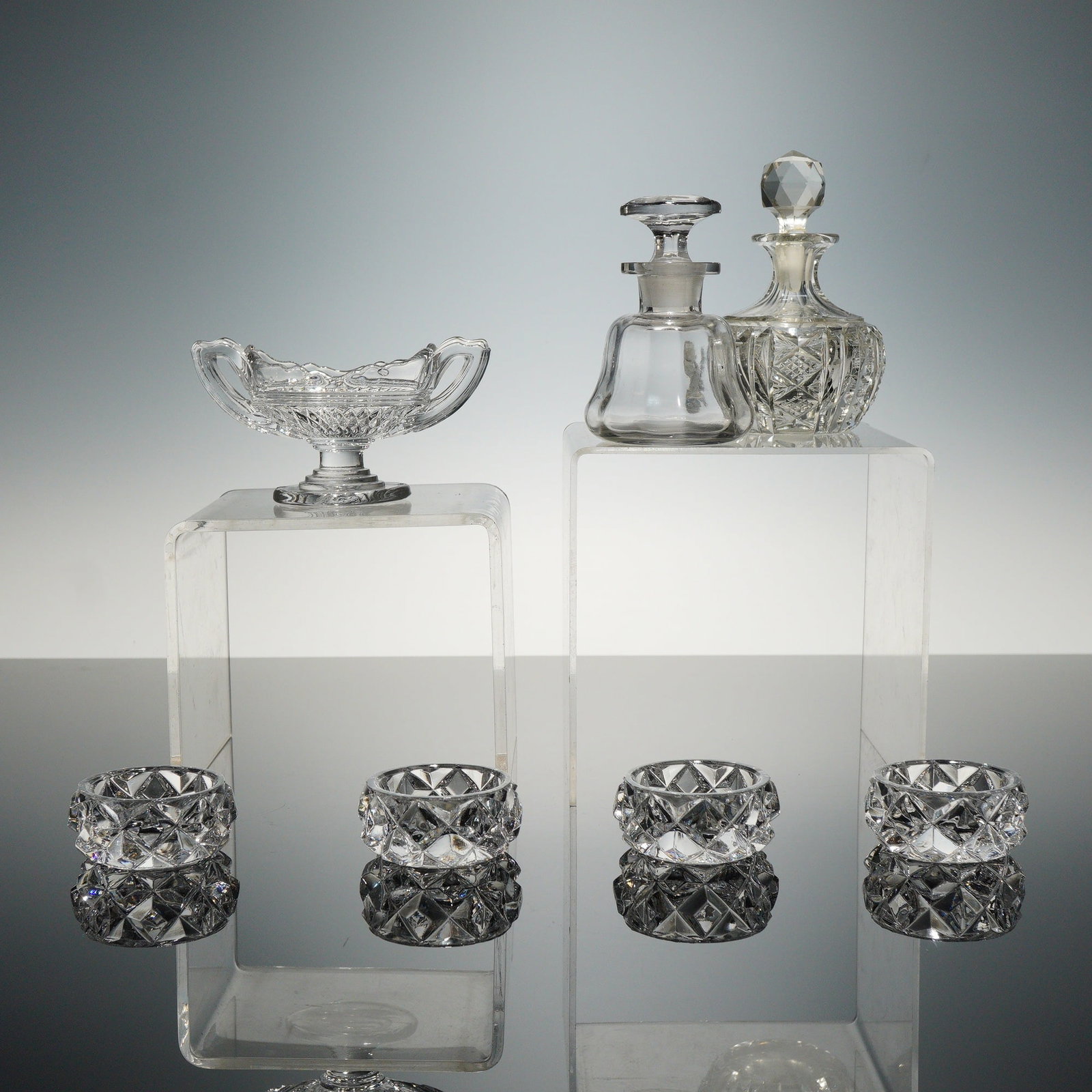 Collection of Seven Cut and Blown Glass Tableware Items: This collection of seven glass tableware items includes a variety of cut and blown misc glass pieces dating from the late 19th to early 20th century. The group features a small two-handled footed bowl
