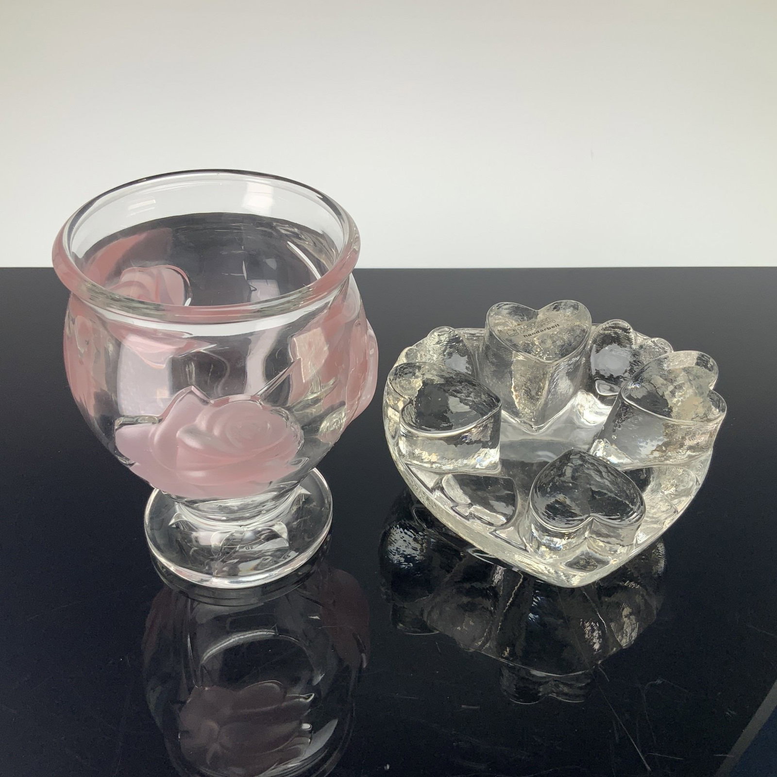 2pc Glass Grouping Including Glasdesign Georgshutte Heart Shaped Warmer and Teleflora Rose Vase: This lot features a 2pc glass grouping including a heart shaped tea light teapot warmer by Glasdesign Georgshutte and a vase with colored raised relief rose motif. The first item is a heavy clear glas