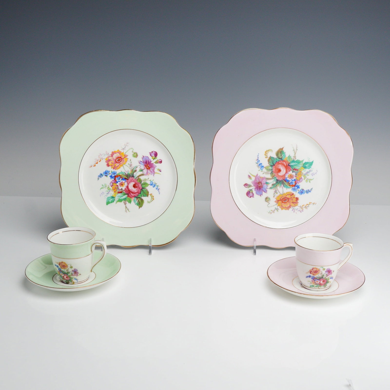 Set of Two Colclough Bone China Tea Trios with Floral Sprays and Pastel Bands: This set of two bone china tea trios was manufactured by Colclough China in Longton, England. The collection is comprised of two teacups, two circular saucers, and two scalloped square dessert plates,