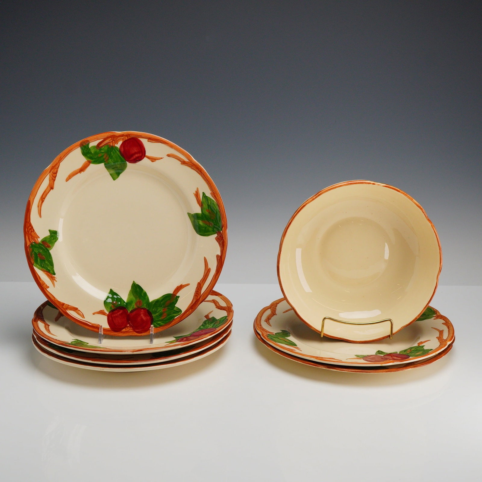 7-Piece Set of Franciscan Earthenware Plates and Bowl, Apple Pattern: This set of Franciscan earthenware features the Apple pattern and includes six plates and a bowl. The pieces are made of glazed earthenware with hand-painted underglaze decoration. The pattern consist