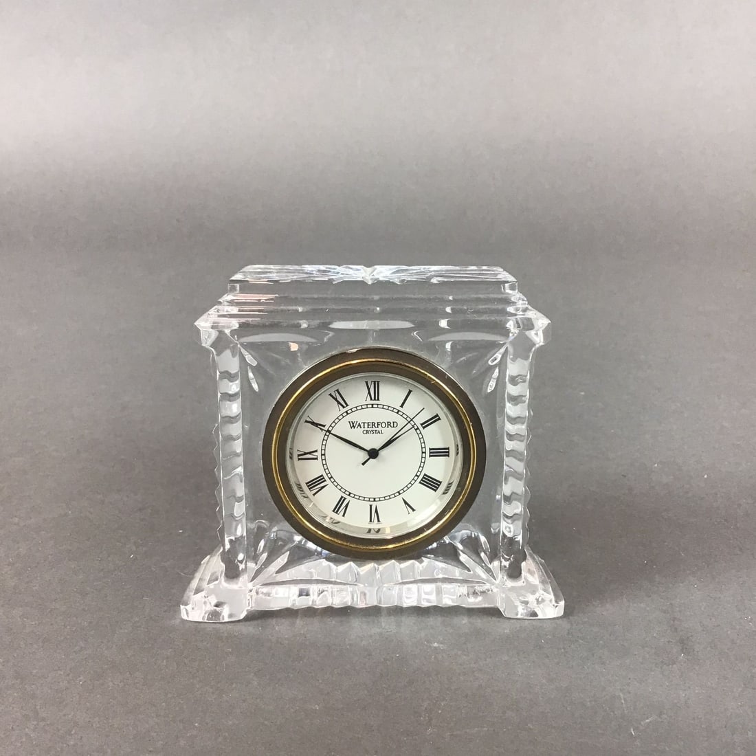 Waterford Crystal Mantel Clock, Pavilion: This Waterford Crystal table clock, in the Pavilion pattern, is made of cut lead crystal. The architectural design features a stepped base and top with deep vertical and geometric wedge cuts. The circ