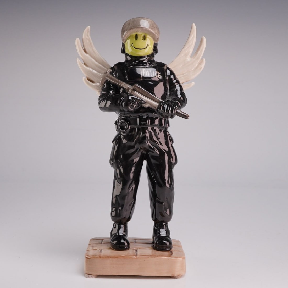 Kevin Francis Street Art Collection Banksy Flying Copper 1/1 Ceramic Figurine by Victoria Bourne: A glazed ceramic figurine from the Kevin Francis Street Art Collection, titled Flying Copper. This piece is inspired by the imagery of street artist Banksy and depicts a riot police officer in full bl