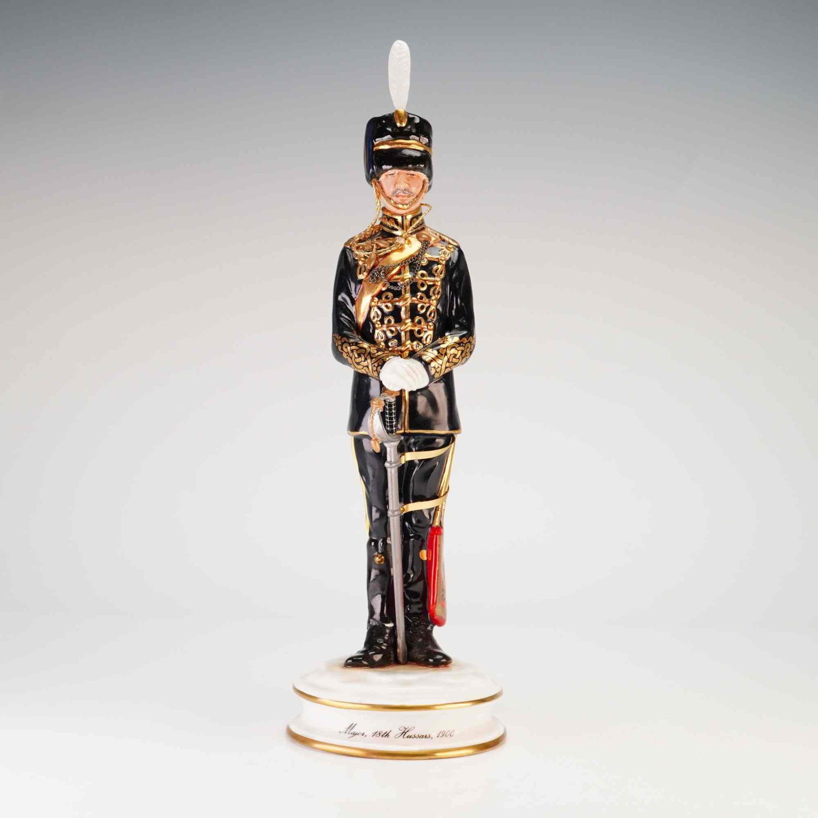 Michael Sutty Limited Edition Porcelain Military Figurine Major 18th Hussars: A Michael Sutty glazed porcelain military figurine depicting a Major of the 18th Hussars in full dress uniform as worn circa 1900. The officer is modeled in a standing pose, wearing a black tunic deco
