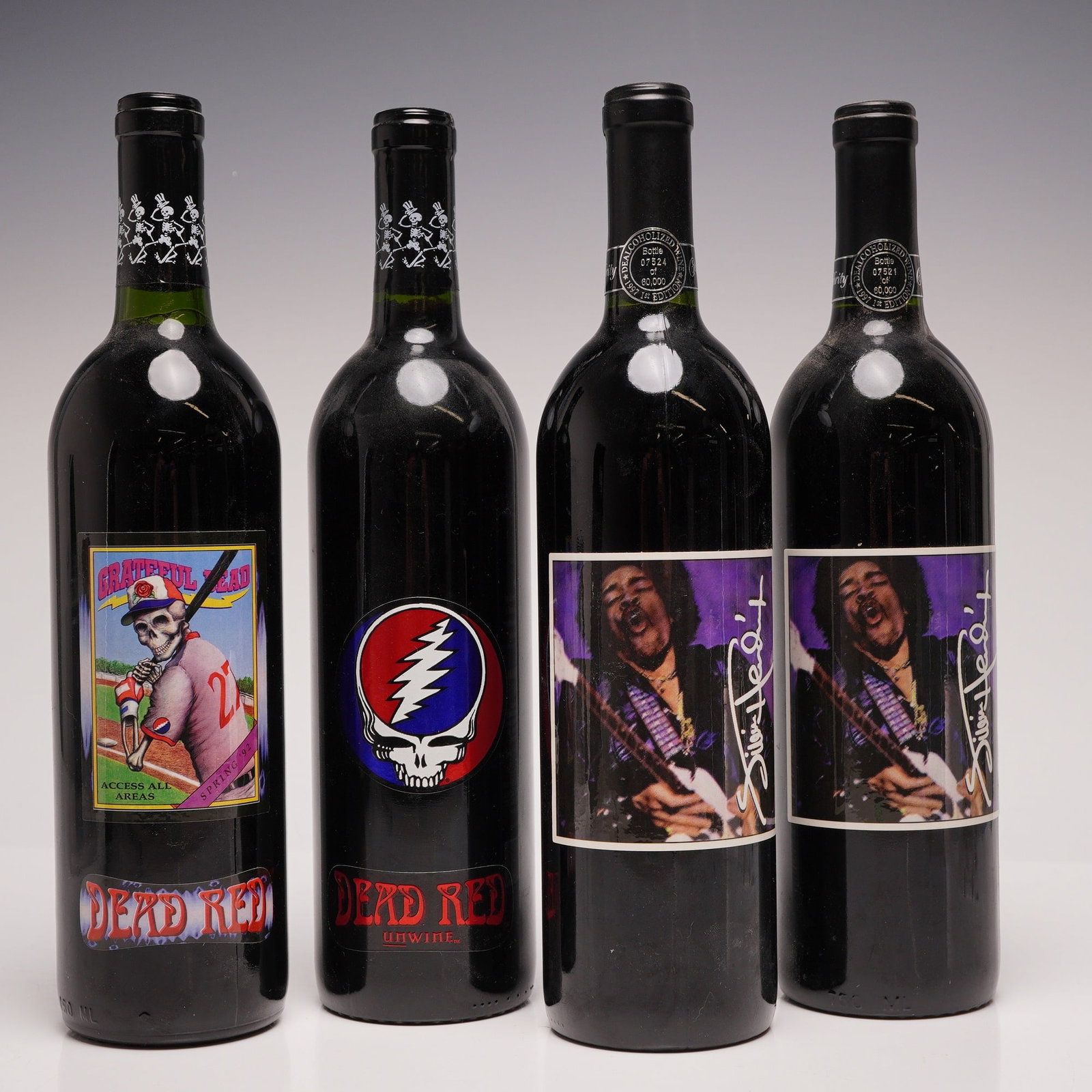 4pc Grateful Dead and Jimi Hendrix De-alcoholized Rock 'n Roll Music Band Collectible Wine Bottles: This collection consists of four 750 ml dark glass bottles of dealcoholized red table wine featuring rock music themes from the 1990s. Two bottles are dedicated to the Grateful Dead, produced by The L