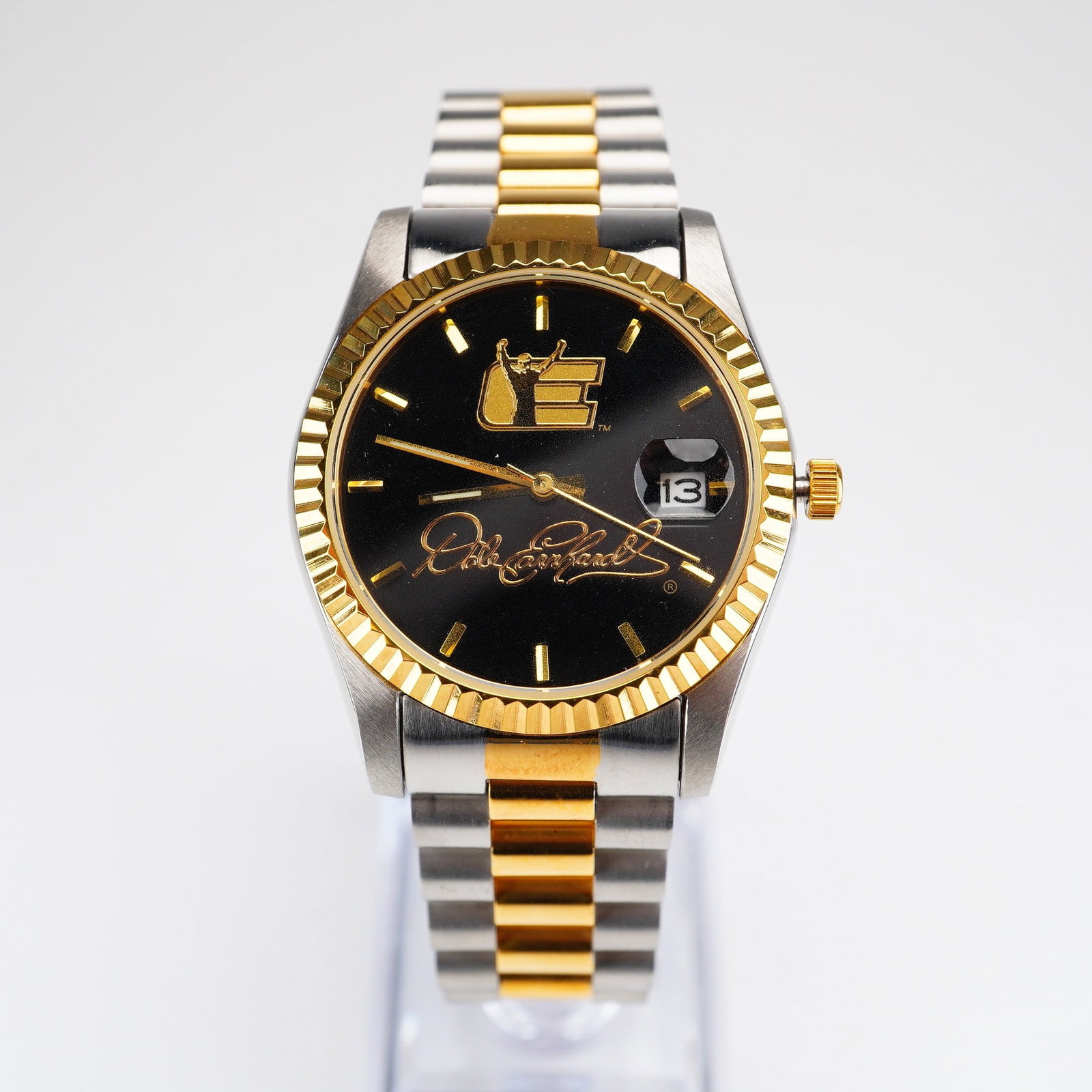 The Bradford Exchange Dale Earnhardt NASCAR Commemorative Two-Tone Quartz Wristwatch: This commemorative men's wristwatch by The Bradford Exchange features NASCAR legend Dale Earnhardt. The timepiece is designed with a two-tone aesthetic, utilizing a stainless steel and gold-tone finis