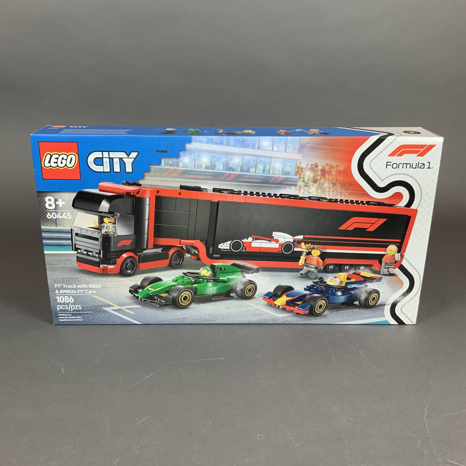 LEGO City Formula 1 Truck with RB20 and AMR24 F1 Cars Set: This is a LEGO City building set, model number 60445, titled F1 Truck with RB20 and AMR24 F1 Cars. The set is produced in collaboration with Formula 1 and includes 1,086 plastic pieces. The primary