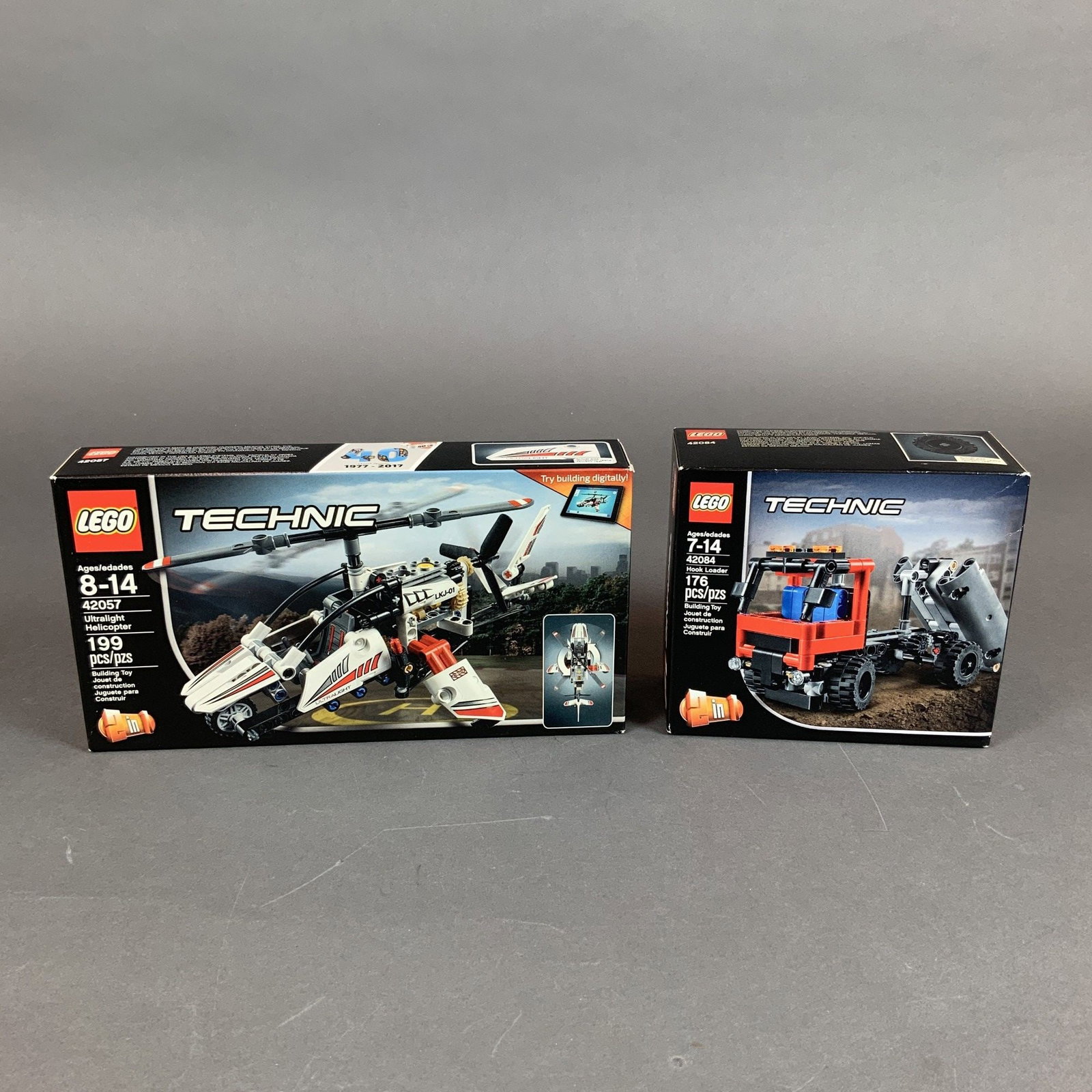 Two LEGO Technic Sets, 42084 Hook Loader and 42057 Ultralight Helicopter: This lot contains two LEGO Technic construction sets in their original manufacturer packaging. The first is set 42084 Hook Loader, a 2-in-1 plastic model with 176 pieces. It features a functional hook