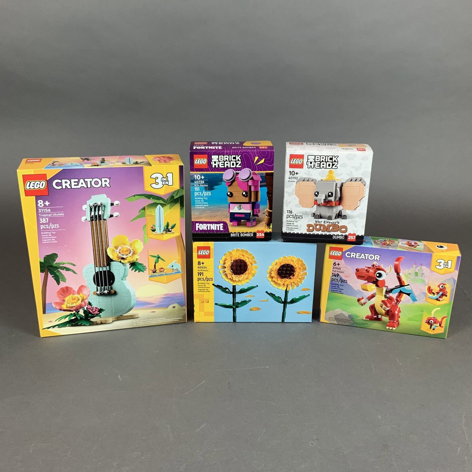 Five LEGO Building Sets Including Creator 3-in-1 BrickHeadz and Botanical Themes: This collection features five contemporary building sets produced by The LEGO Group, encompassing various themes and piece counts. The assortment includes: LEGO Creator 3-in-1 Red Dragon (Set 31145) c