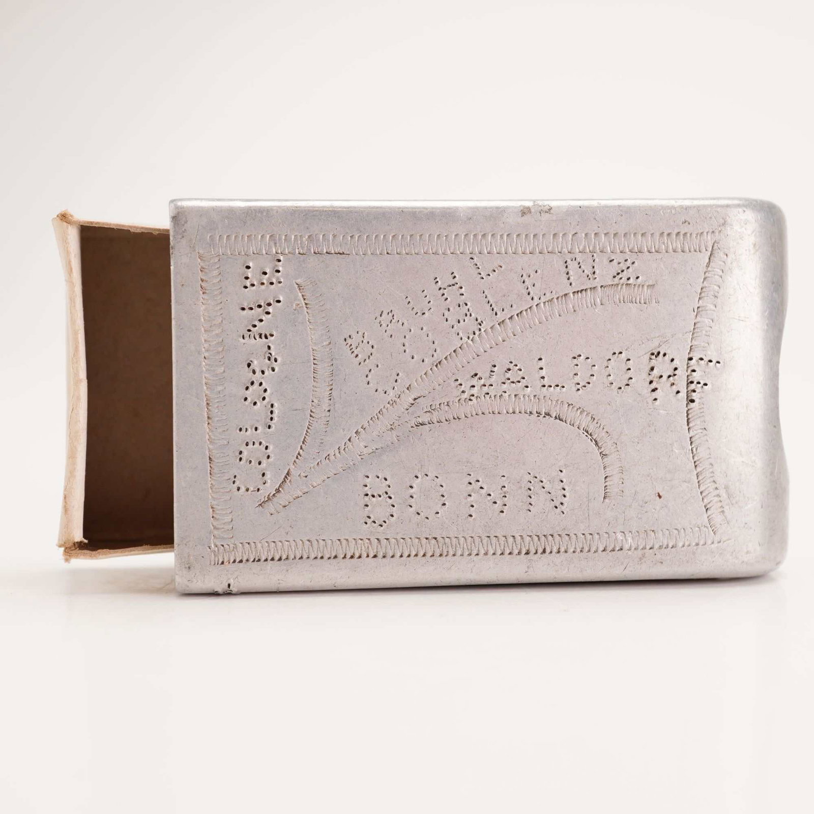 WWI Aluminum Trench Art Match Case with 1919 German Occupation Cities and Matchbox: This lot includes a hand-decorated aluminum matchbox sleeve, an example of World War I trench art, and a vintage cardboard matchbox. The sleeve is made from stamped and stippled aluminum, featuring ha