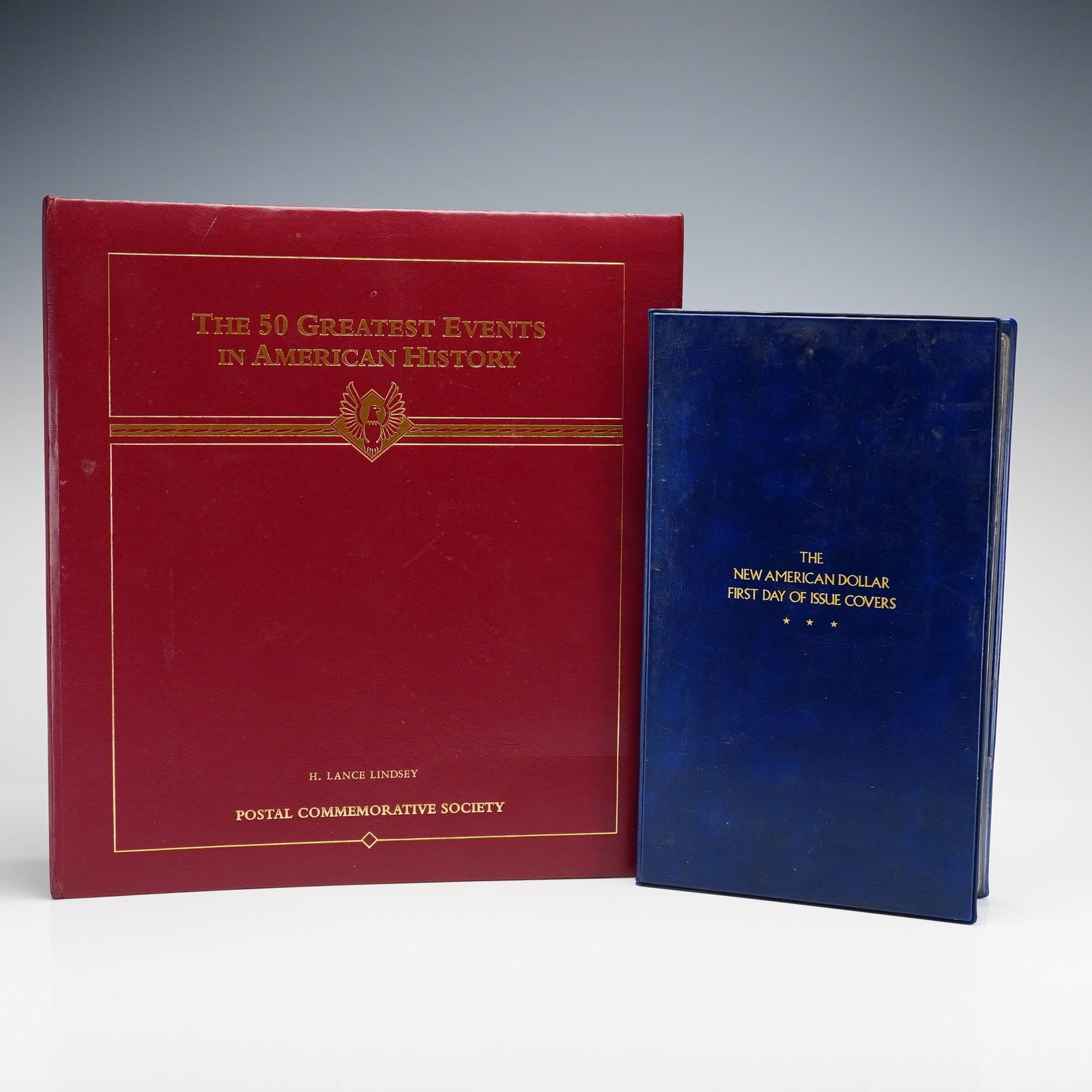 2pc The 50 Greatest Events in American History Vol.2 and The New American Dollar First Day of Issue: This lot comprises two commemorative collections produced by the Postal Commemorative Society. The first item is titled The 50 Greatest Events in American History, authored by H. Lance Lindsey. It is 
