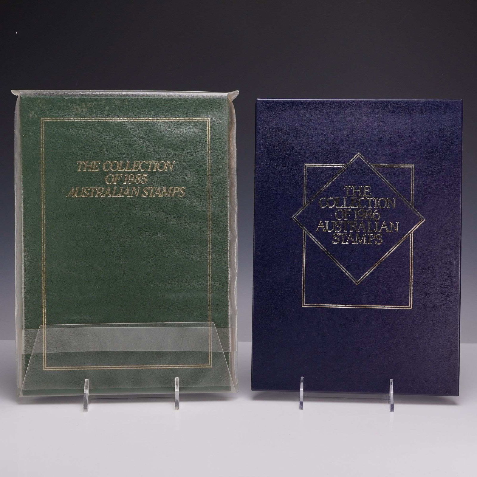 Set of Two AU 1985 and 1986 Annual Stamp Collection Yearbooks: This lot features 2 sets of Australian stamps presented in the official Australia Post annual collection yearbooks for 1985 and 1986. The 1985 volume is bound in a green textured cover with gold-stamp