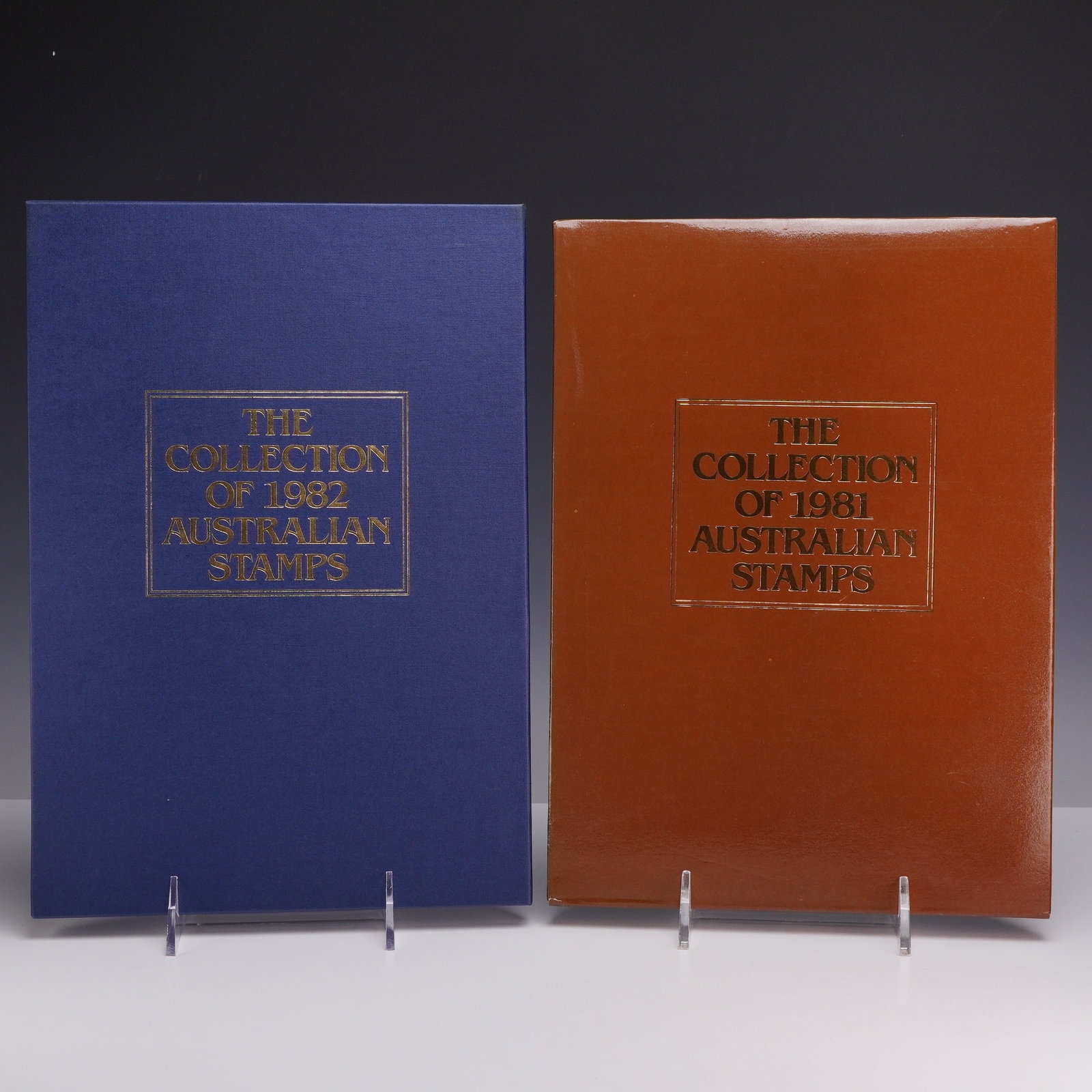 Set of Two Australian 1981 and 1982 Annual Stamp Collections: Two official Australia Post annual stamp collection albums for the years 1981 and 1982. Each collection is presented in its original slipcase: brown for 1981 and blue for 1982. The volumes contain the
