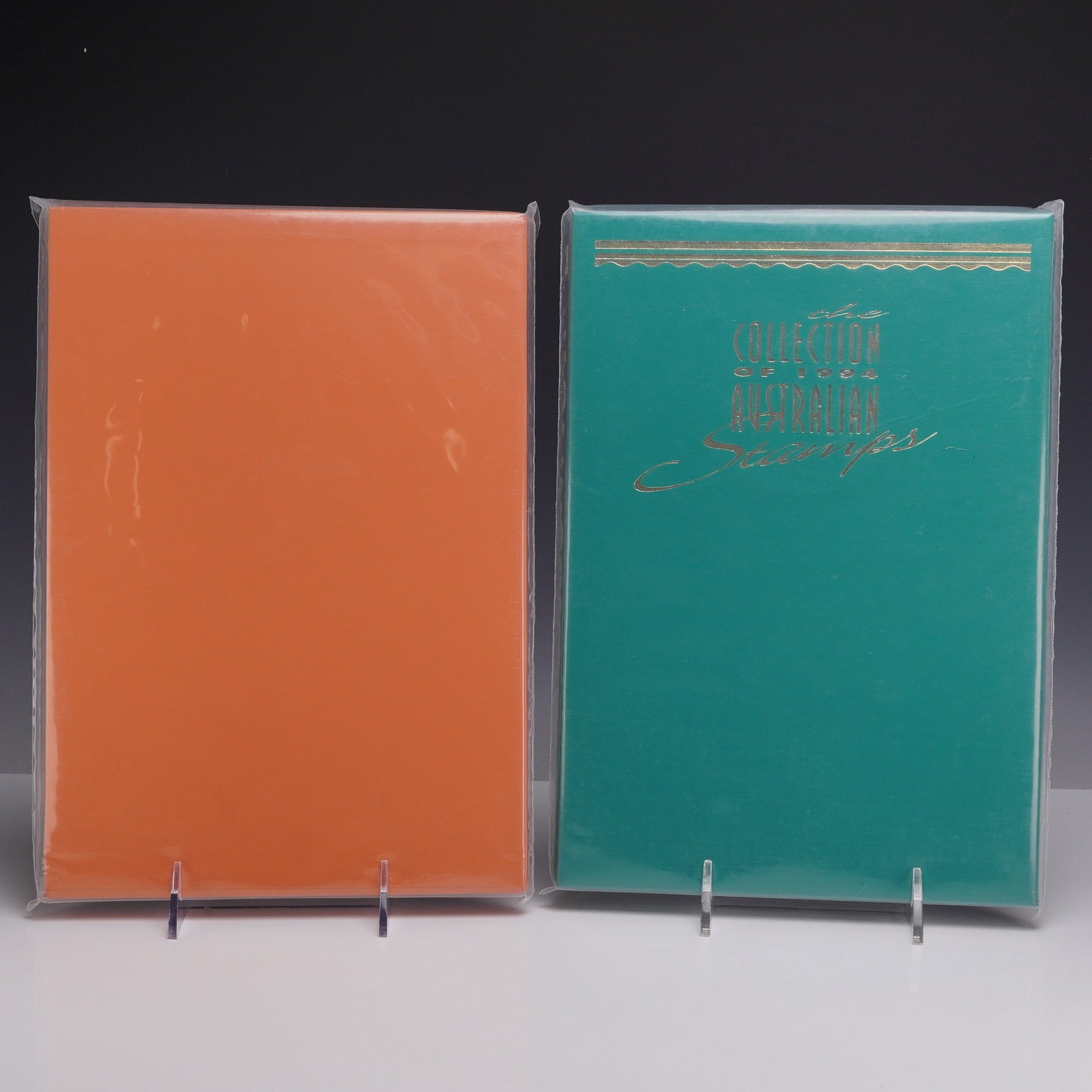 Set of Two Australian 1993-1994 Deluxe Edition Annual Stamp Collections: Two Australia Post deluxe edition annual stamp collections for the years 1993 and 1994. The 1993 volume is presented in an orange slipcase and matching cover with gold embossing. This edition contains