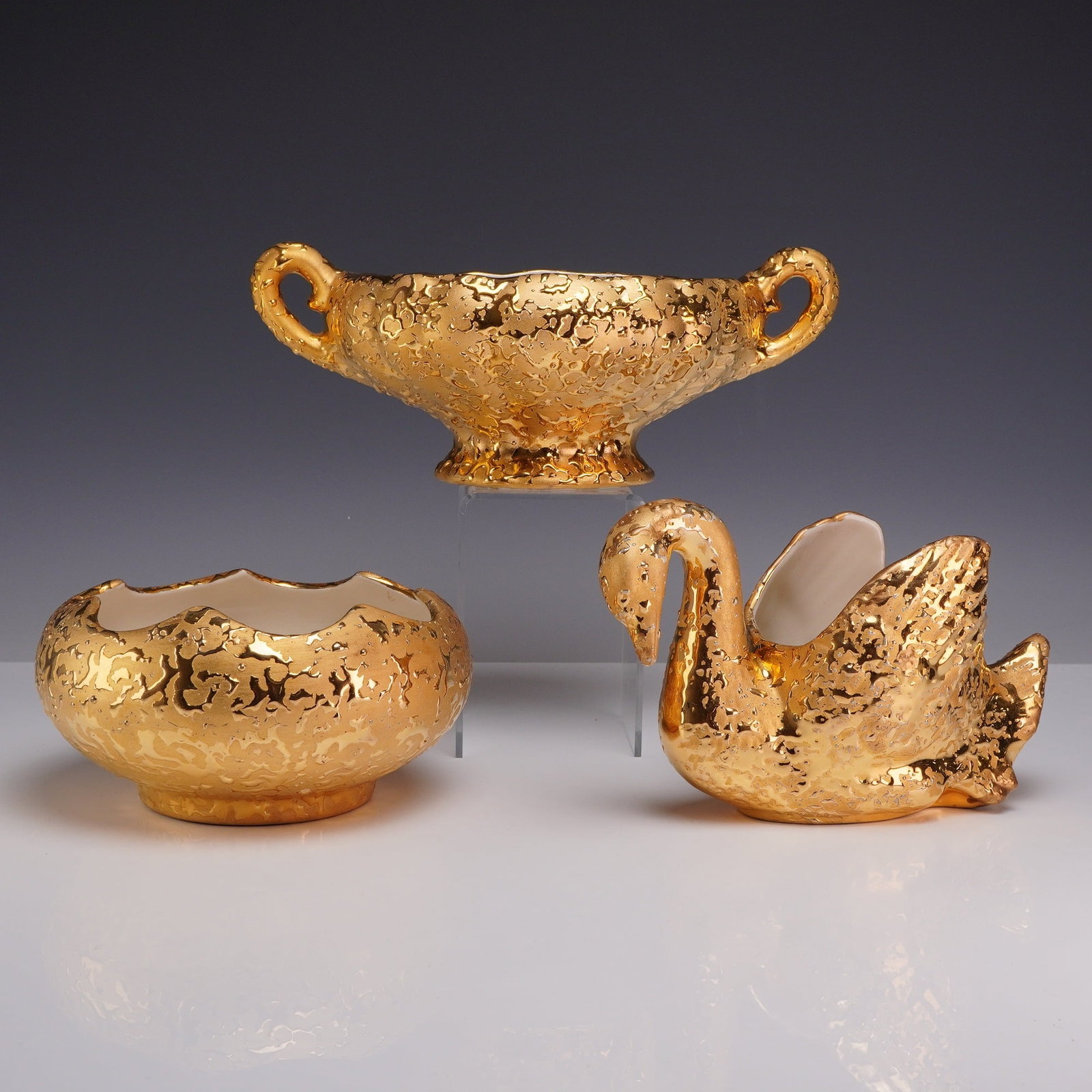 Three Gold Craft Weeping Bright 22kt Gold Hand Decorated Centerpiece Bowls: This set of three mid-century American decorative ceramic items features a heavily textured metallic luster finish known as weeping gold. The collection includes a footed centerpiece bowl with two scr