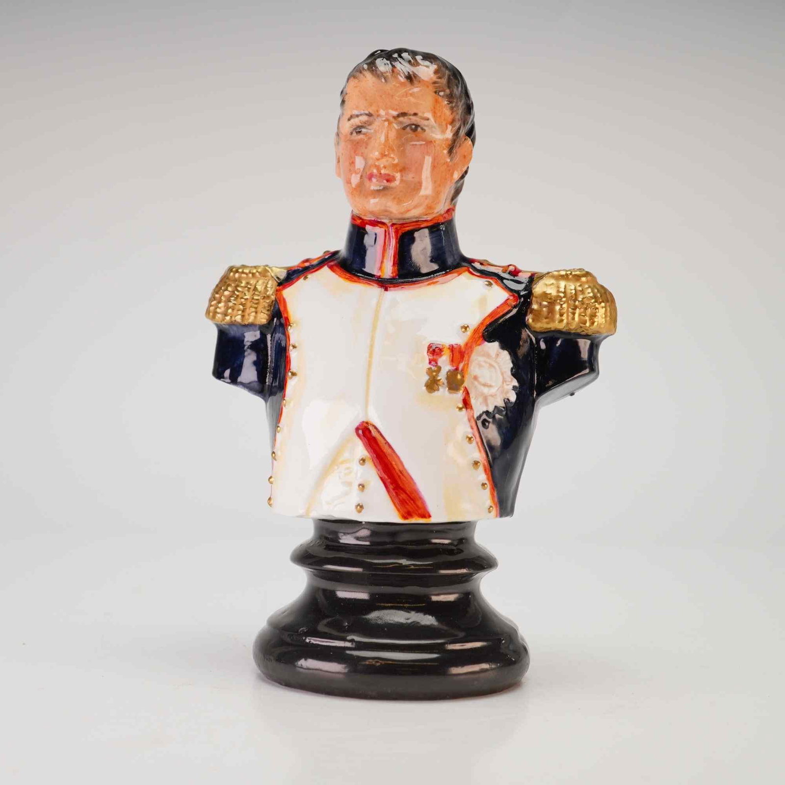Michael Sutty Limited Edition Porcelain Bust of Napoleon Bonaparte: This hand-painted porcelain bust of Napoleon Bonaparte was produced by the Michael Sutty Porcelain Manufactory in England. The figure is modeled in a military uniform featuring a white lapelled tunic 