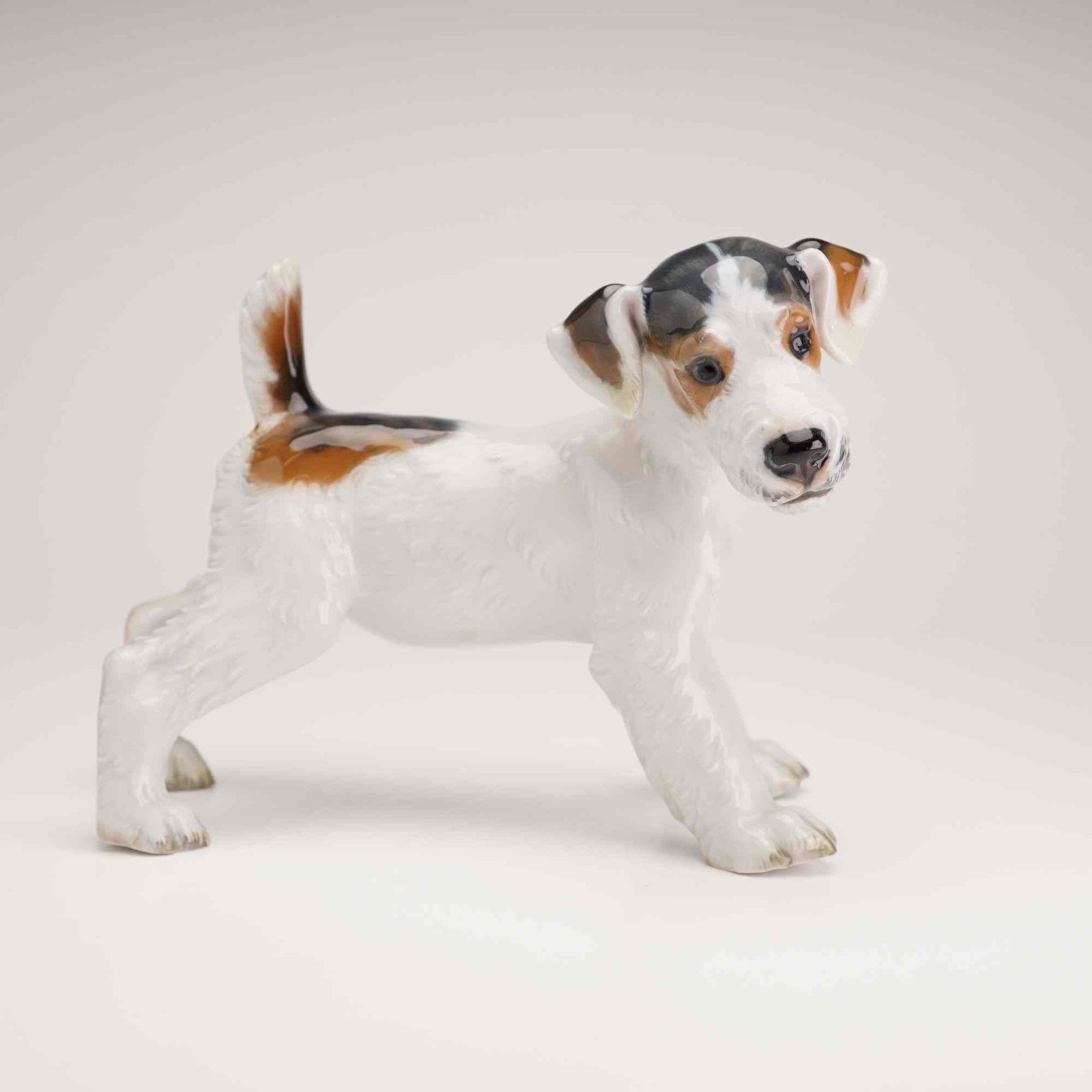 Rosenthal Porcelain Wire-Haired Fox Terrier Dog Figurine: A Rosenthal porcelain figurine of a Wire-Haired Fox Terrier dog, model number 1124. The dog is depicted in a standing, alert pose with its tail raised. It is constructed of polychrome glazed porcelain