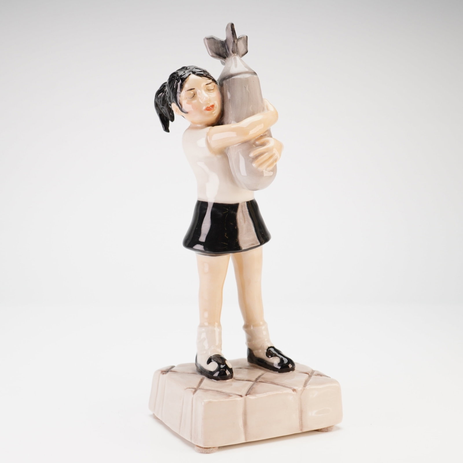 Kevin Francis Ceramics Limited Edition Banksy Bomb Hugger Figurine: Kevin Francis Ceramics limited edition figurine titled Banksy's Bomb Hugger, numbered 22 of 100. This hand-painted, glazed ceramic figure depicts a young girl with a black ponytail, wearing a white to