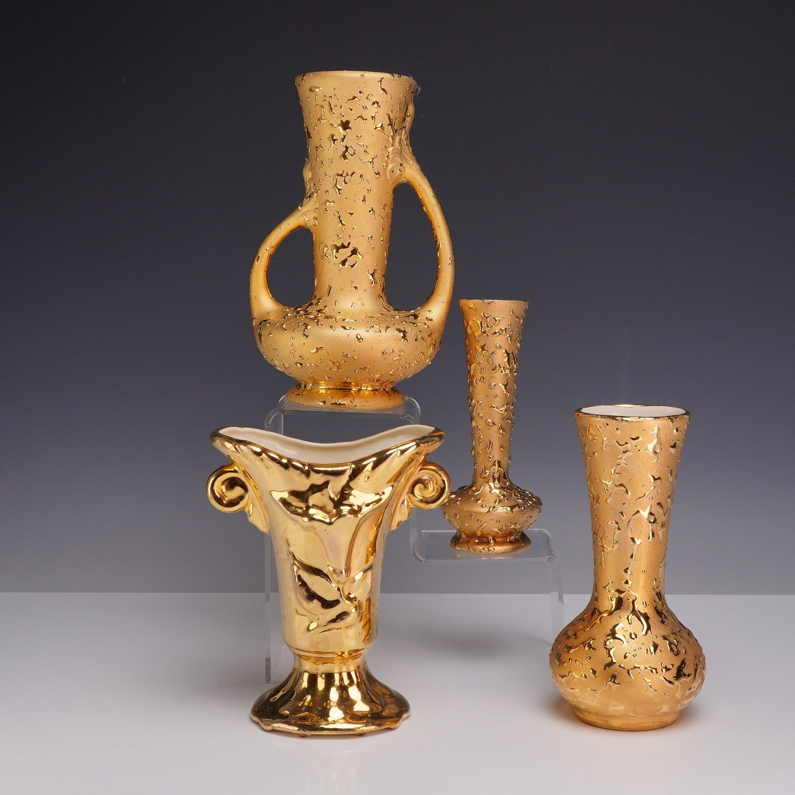 Four American Mid-Century 22 & 24k Weeping Gold Porcelain Vases: The collection includes three pieces finished in the "weeping gold" style, a technique involving a textured, heavy gold-infused glaze. These forms include a tall vase with two large looping handles an