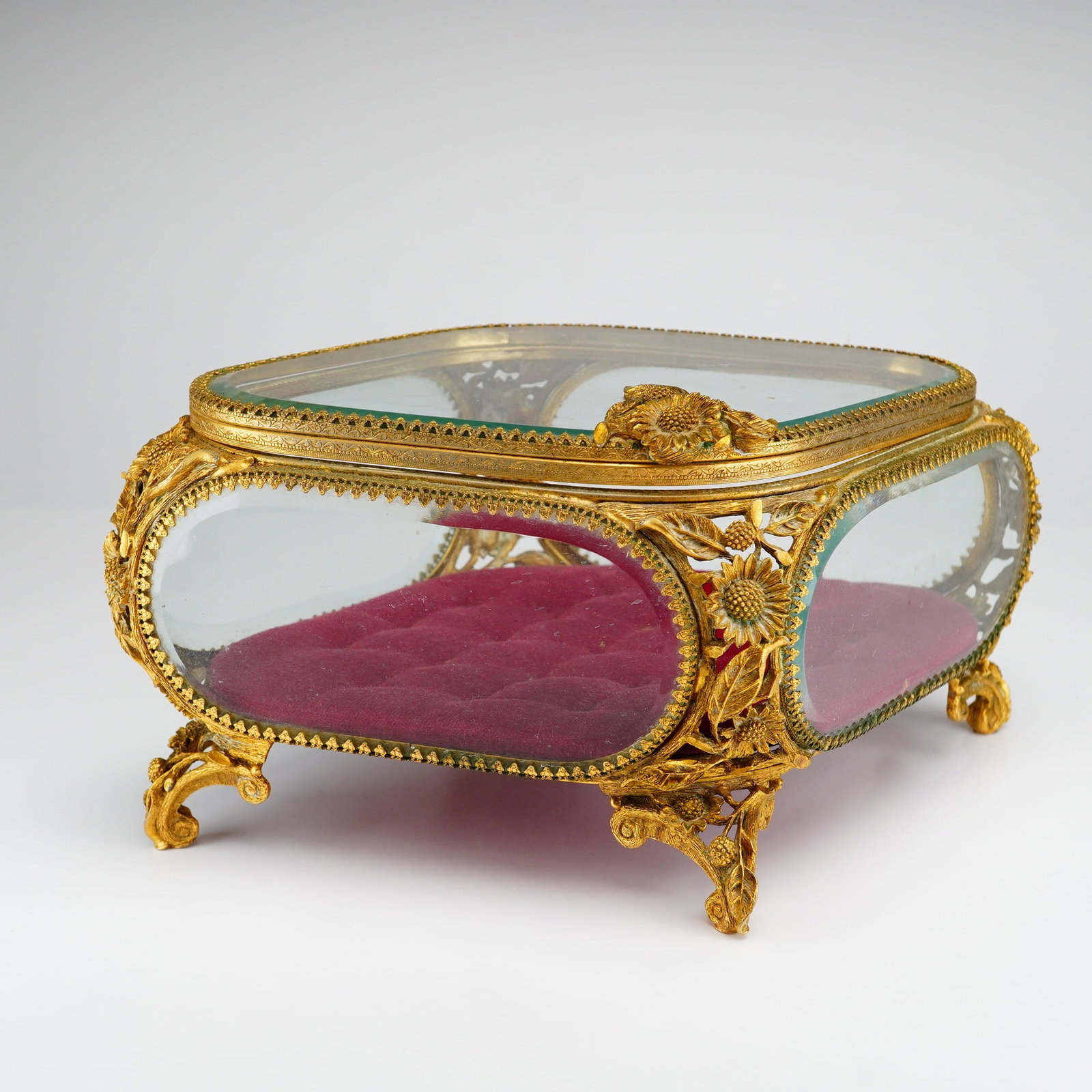 Matson Ormolu Jewelry Box Casket with Beveled Glass and Sunflower Motifs: A vintage footed jewelry box or vanity casket produced by Matson. The piece features a gilt metal frame with a gold-toned finish, constructed with five thick beveled glass panels, including the hinged
