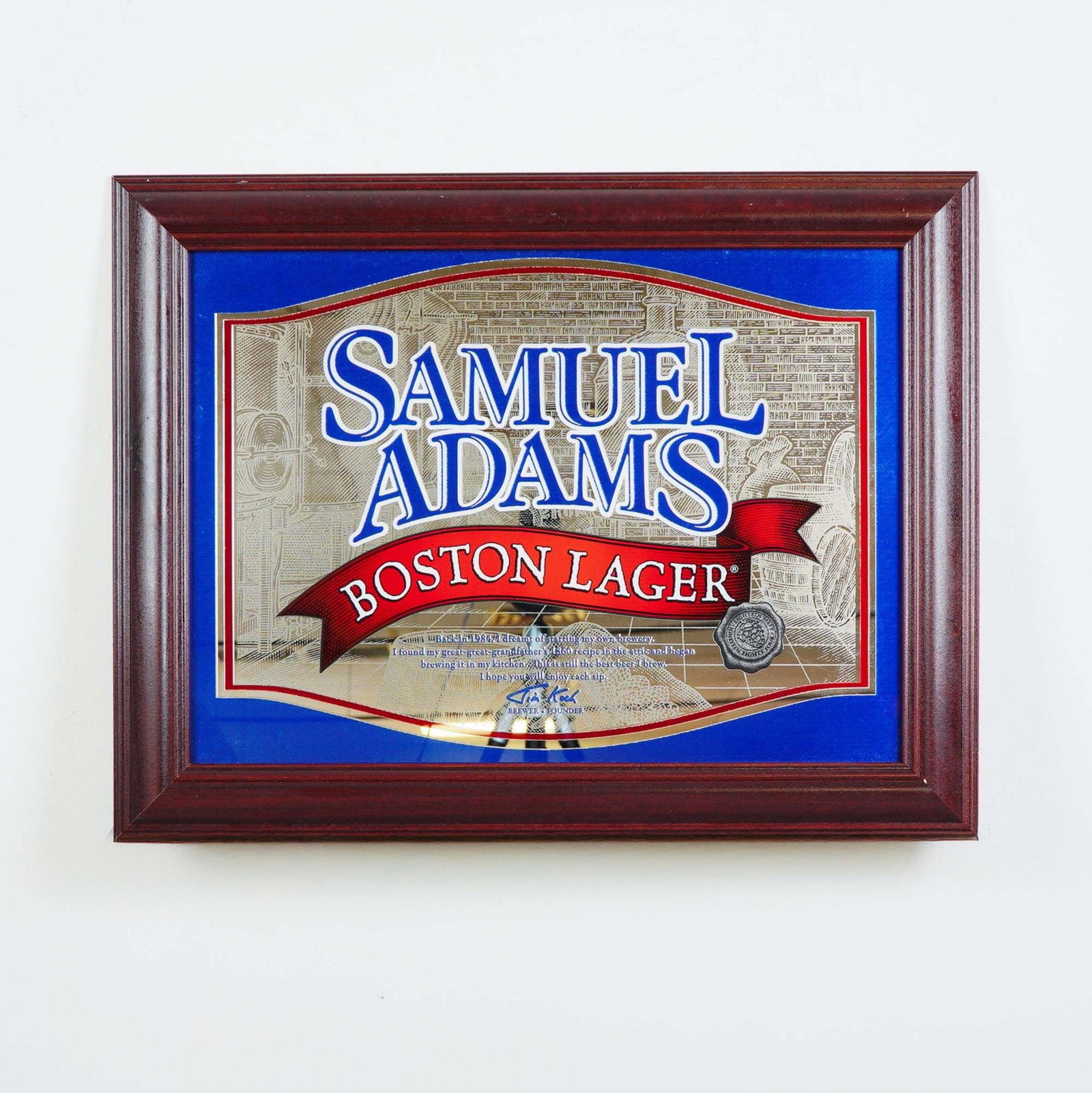 Samuel Adams Boston Lager Mirror Sign in Wooden Frame: Offered here is a striking Samuel Adams Boston Lager advertising mirror, beautifully framed in rich wood. This classic piece features the bold Samuel Adams branding in vivid blue and red against a det