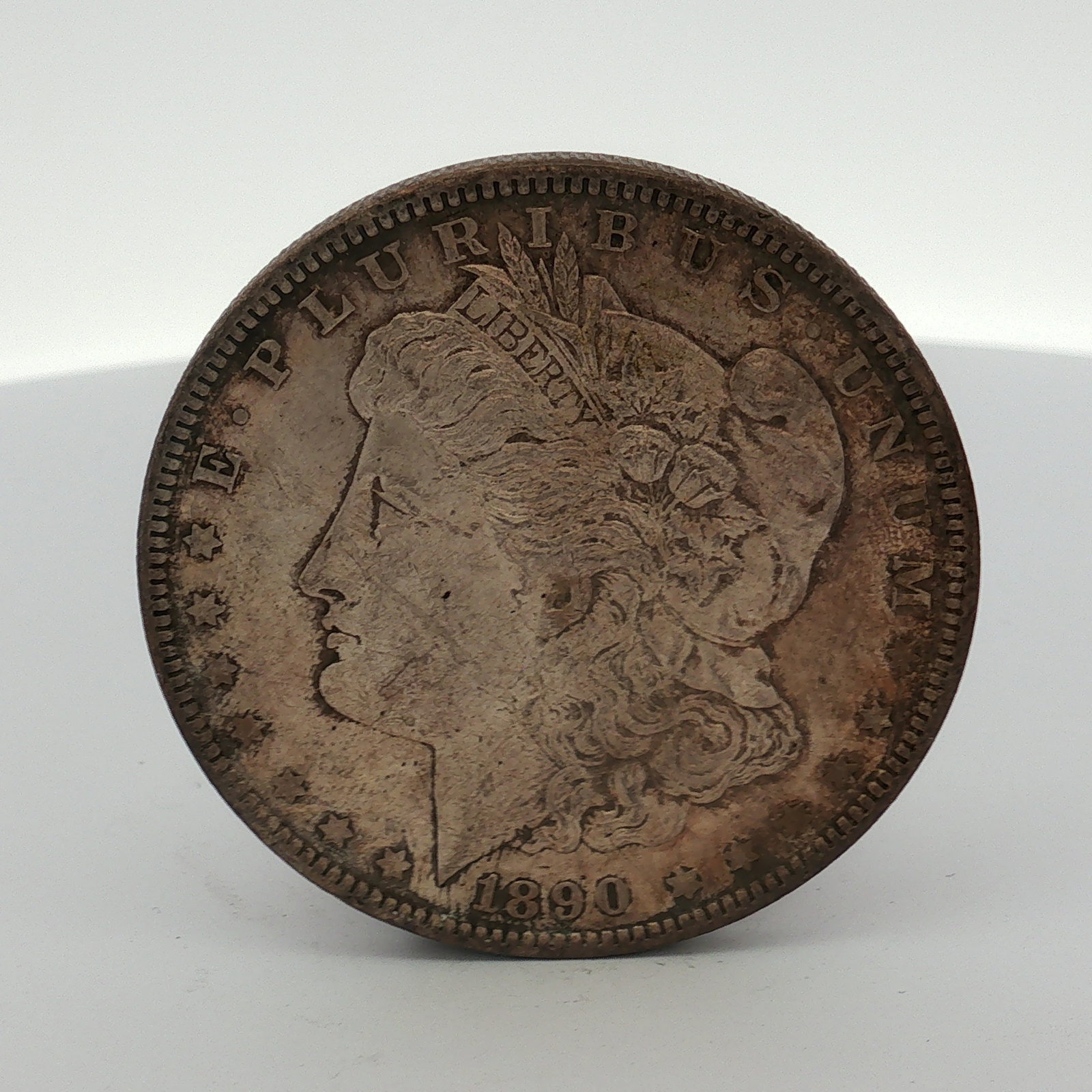 1890 US Morgan Silver Dollar Coin Circulated: This US 1890 Morgan silver dollar is a Philadelphia Mint issue. The coin is struck in .900 fine silver and .100 copper. It features the Morgan design obverse and reverse. The obverse includes the date