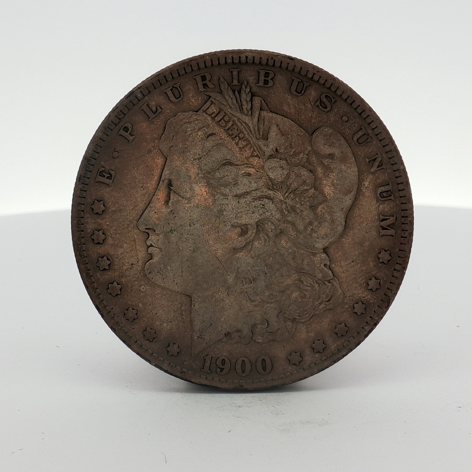 1900-S US Morgan Silver Dollar Coin Circulated: This 1900-S US Morgan silver dollar was struck at the San Francisco Mint. The coin is a silver dollar featuring the Morgan dollar design and is dated 1900. It is composed of .900 fine silver and .100 