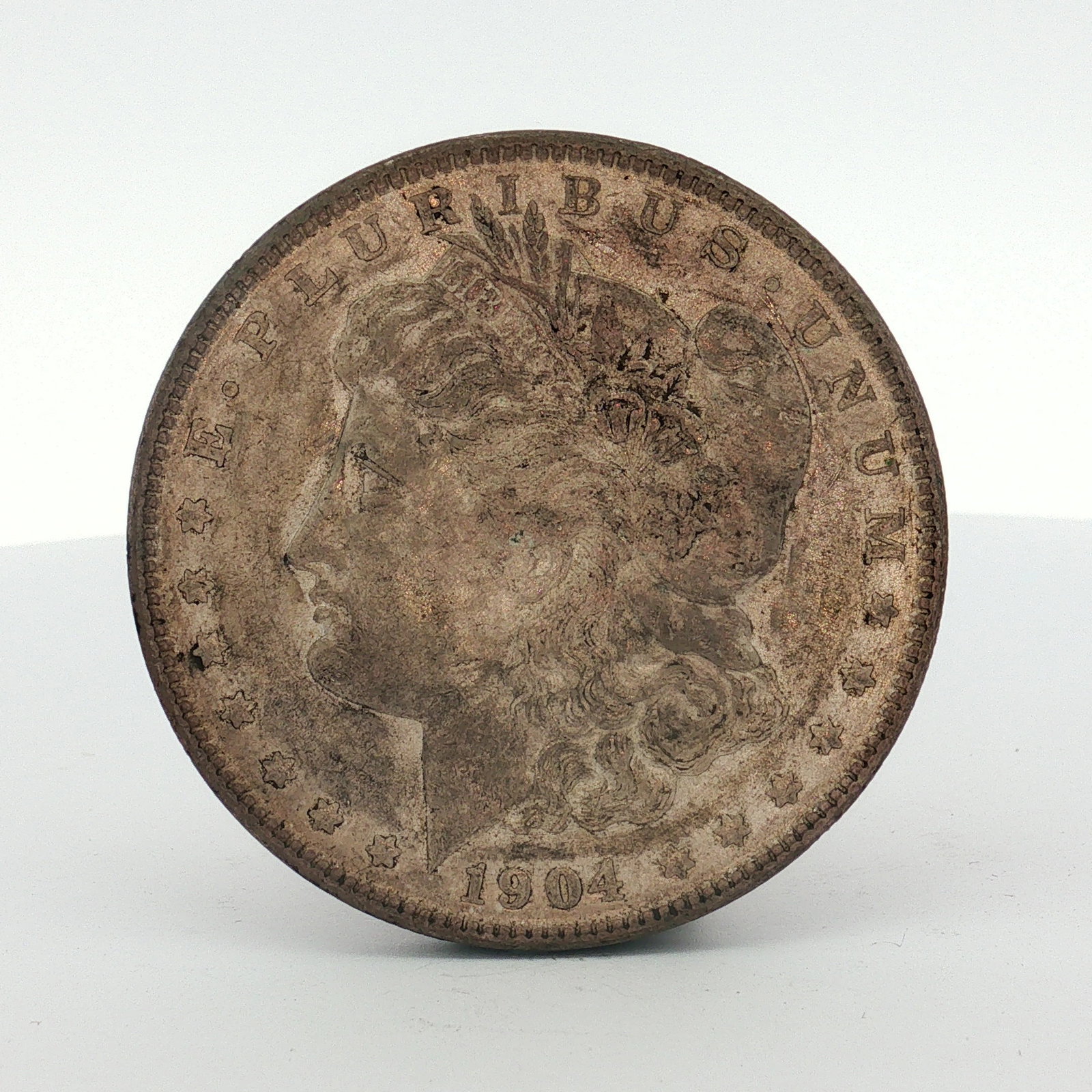 1904-S US One Dollar Morgan Silver Dollar, Circulated: This US Morgan dollar was struck at the San Francisco Mint in 1904. The coin is composed of 90 percent silver and 10 percent copper. The obverse features the Liberty head design and the reverse featur