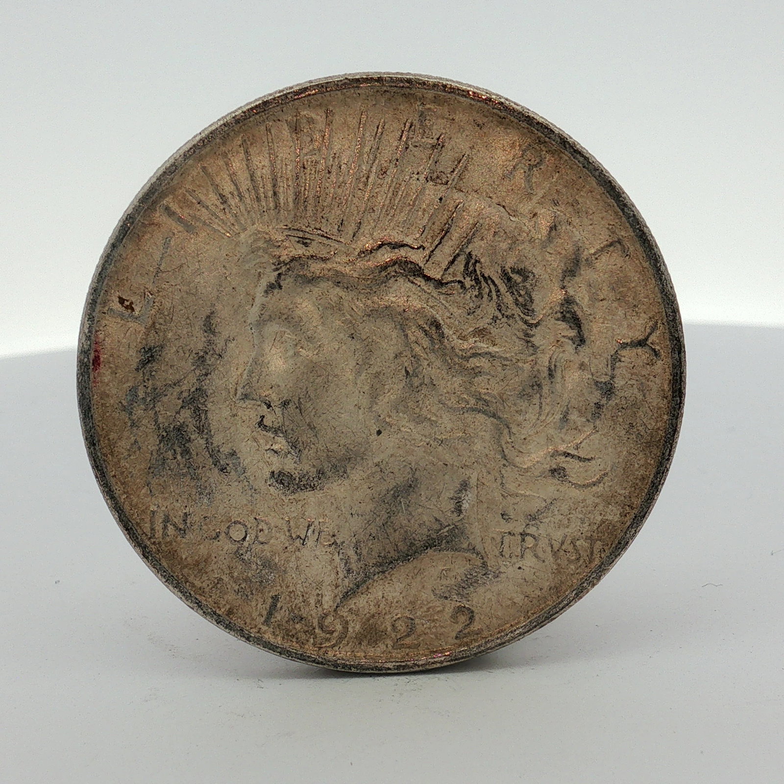 1922-D US One Dollar Peace Silver Dollar, Circulated: This US 1922 Peace dollar is a silver coin struck at the Denver Mint. The coin features the Peace dollar obverse and reverse designs. It is composed of 90 percent silver and 10 percent copper. The D m