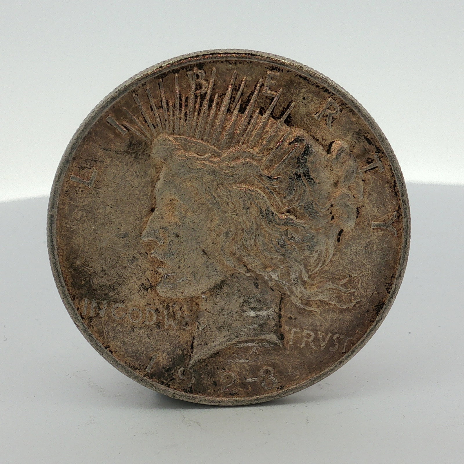 1923-D US One Dollar Peace Silver Dollar, Circulated: This 1923-D US Peace silver dollar was struck at the Denver Mint. The coin is composed of 90% silver and 10% copper. It features the Peace dollar obverse and reverse designs. Obverse inscriptions incl