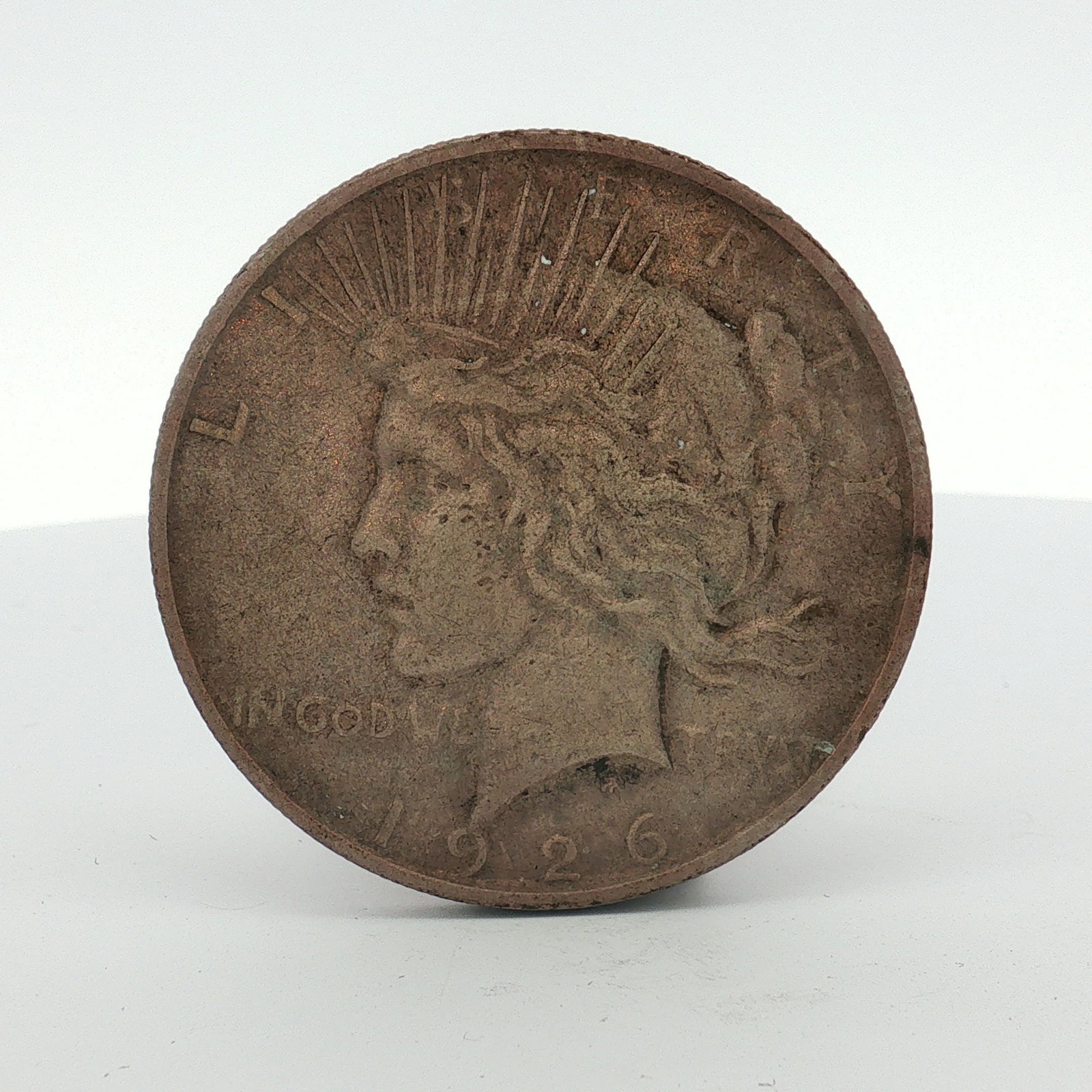 1926-D US One Dollar Silver Peace Dollar, Circulated: This 1926-D US Peace silver dollar is composed of 90 percent silver and 10 percent copper. The obverse features the Liberty design with inscriptions LIBERTY, IN GOD WE TRUST, and the date 1926. The re
