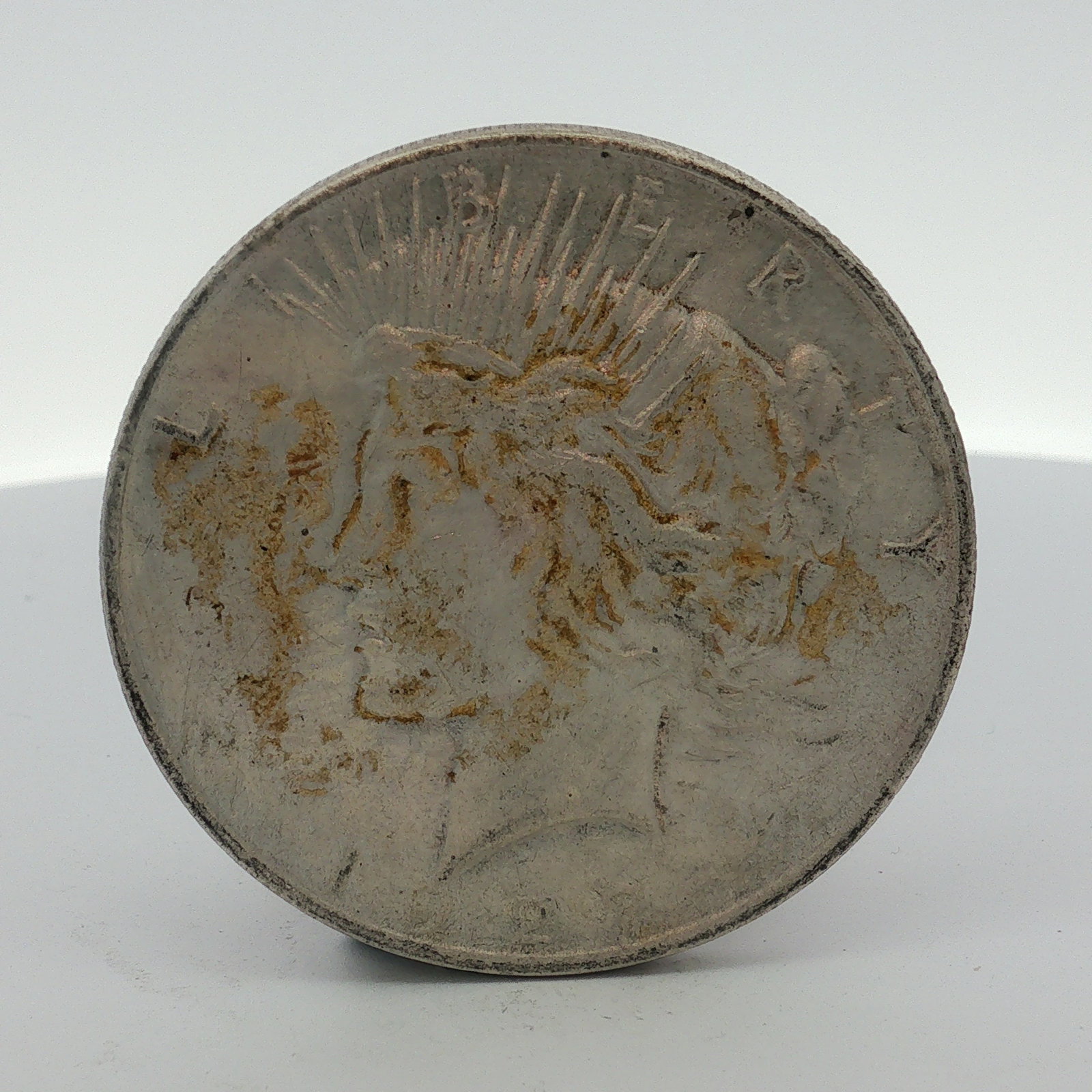 1927-D US One Dollar Peace Silver Dollar, Circulated: This US 1927-D Peace silver dollar is struck in a 90% silver and 10% copper alloy at the Denver Mint. The obverse features the Liberty head design with the inscription LIBERTY and a partial date of 19