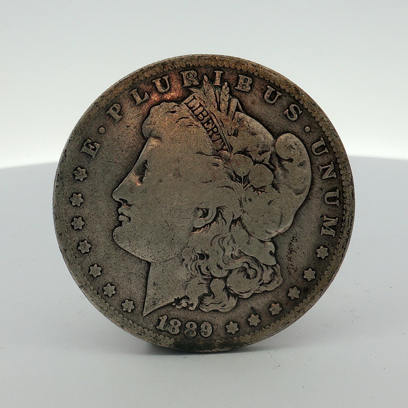 US 1889-O Morgan Silver Dollar: This US 1889-O Morgan silver dollar was struck at the New Orleans Mint. The coin features the George T. Morgan designed Liberty Head obverse and the Eagle reverse. It is composed of 90 percent silver 