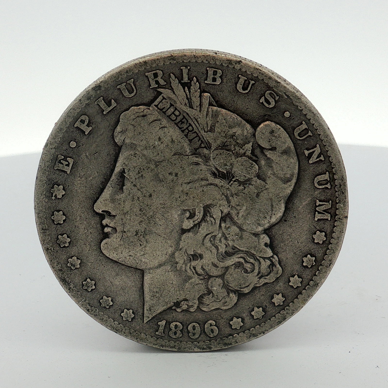 US 1896-O Morgan Silver Dollar: This US Morgan dollar is dated 1896 and features the O mint mark for the New Orleans Mint. The coin is struck in .900 fine silver. It features the Morgan obverse and reverse designs. The O mint mark i