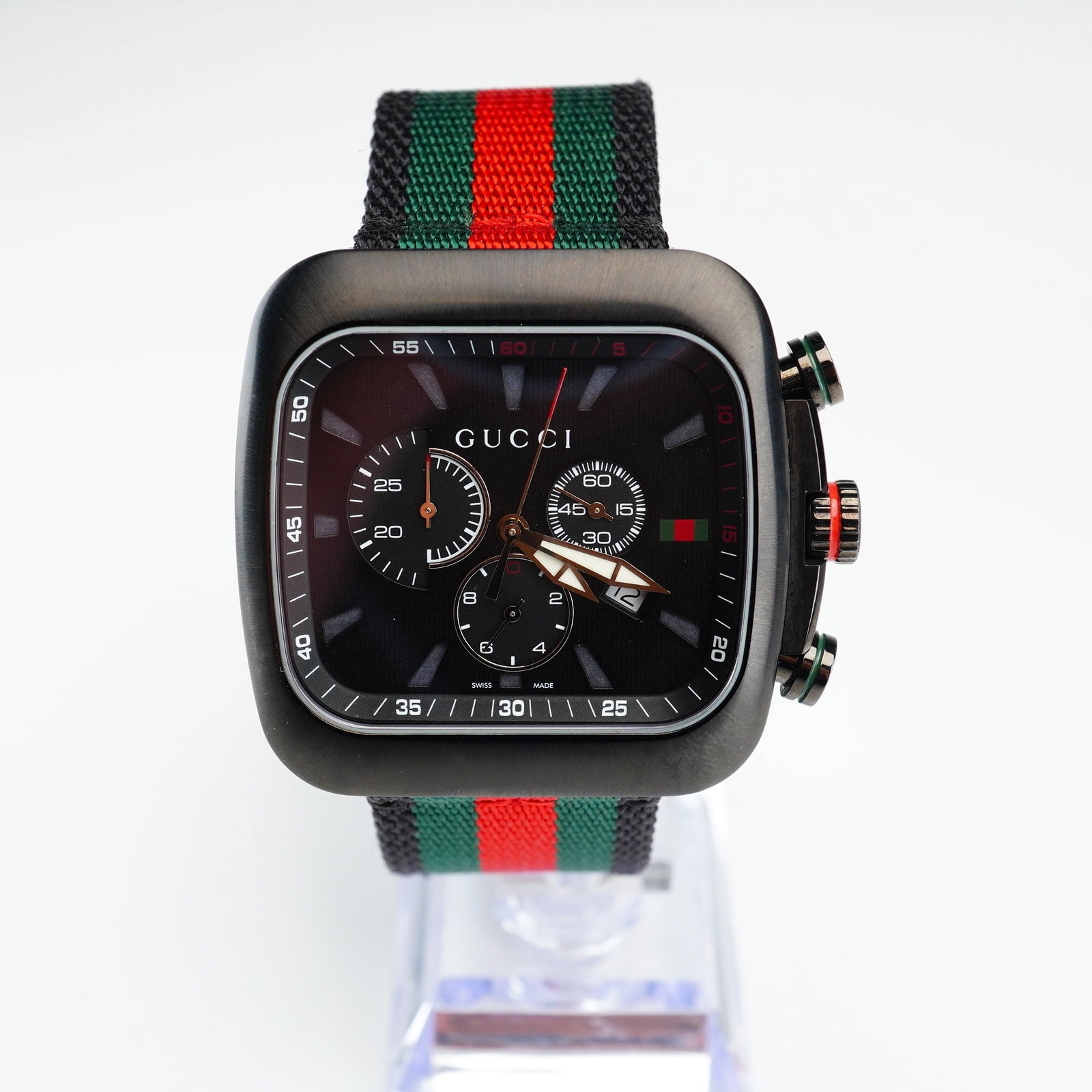 Gucci Men's Coupe Chronograph Quartz Black Two-Tone NATO Strap Watch: This timepiece showcases a bold 44 x 44 mm black PVD stainless steel case complemented by a distinctive red and green nylon strap. The watch features an elegant black guilloche dial and is powered by 
