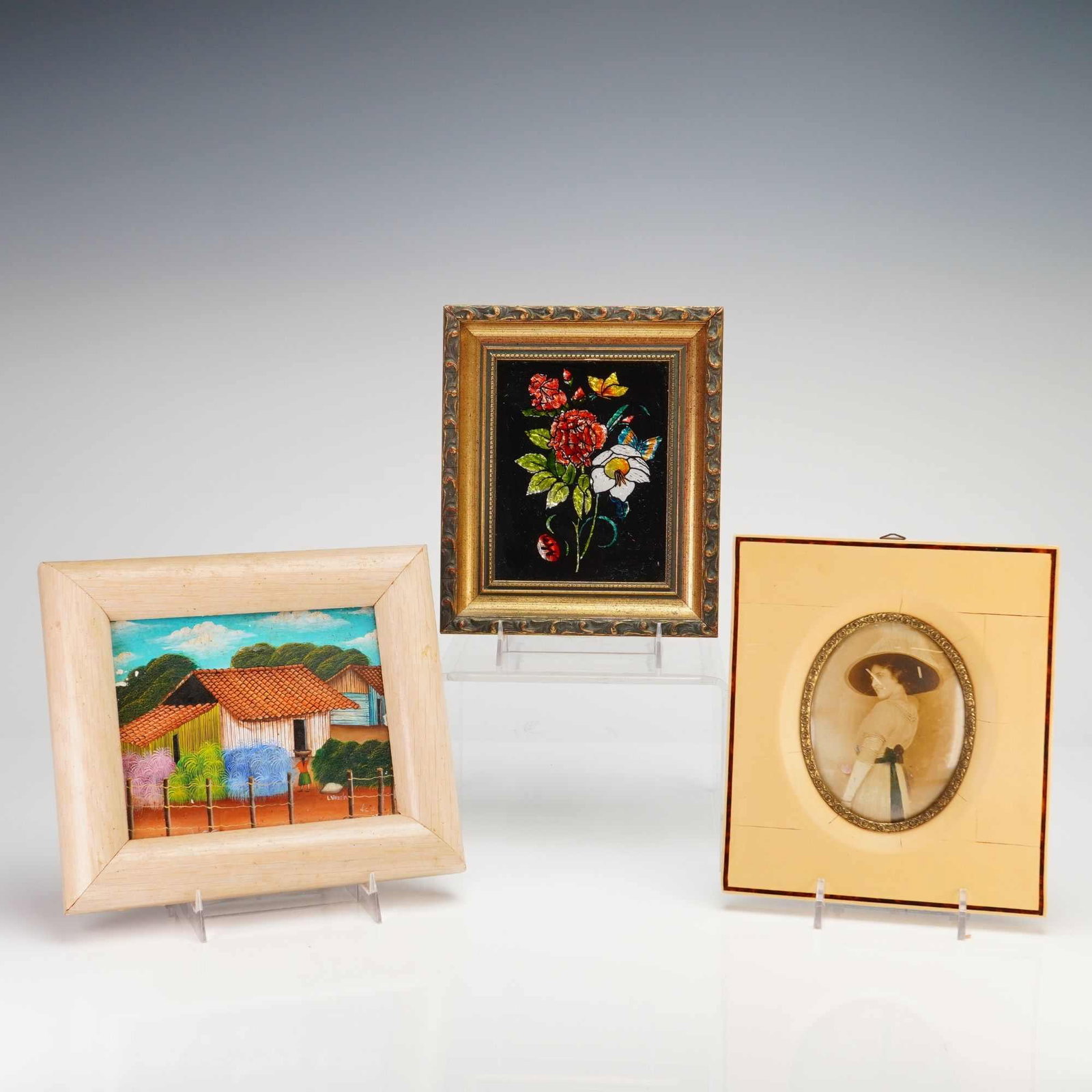 Elizabeth L. Zytko and L. Varela, A Trio of Artworks including 'Floral Bouquet' and 'Rural: Elizabeth L. Zytko (American, 20th Century). A 3pc framed eglomise glass painting featuring a floral bouquet with butterflies against a black ground. The work is housed in an ornate gilded molded fram
