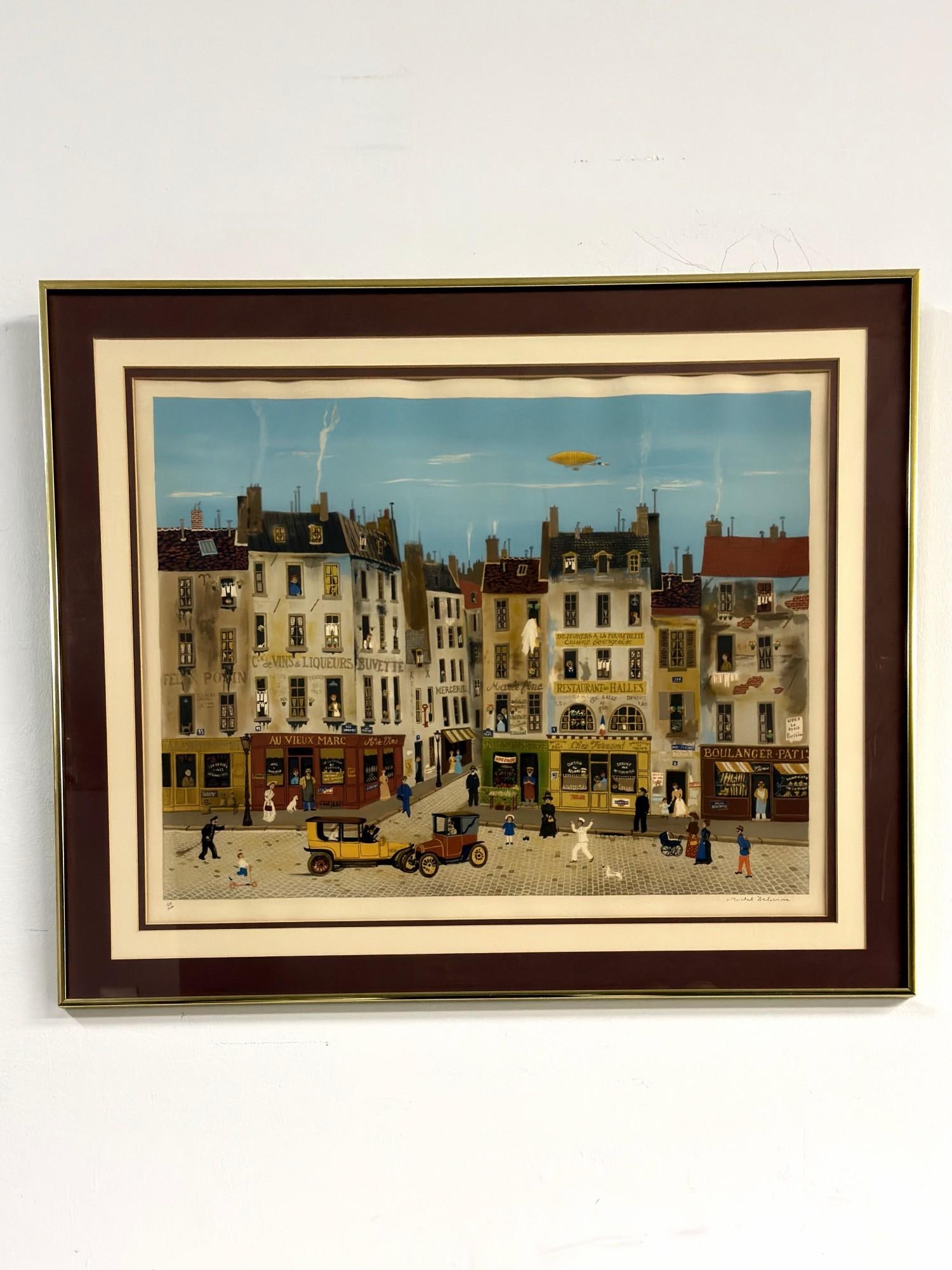 Michel Delacroix (French, b. 1933) Lithograph on Paper, Paris Street, Signed & Numbered: This limited edition framed lithograph by French artist Michel Delacroix depicts a Parisian street scene rendered in a Naif style. The composition features various storefronts with French signage incl