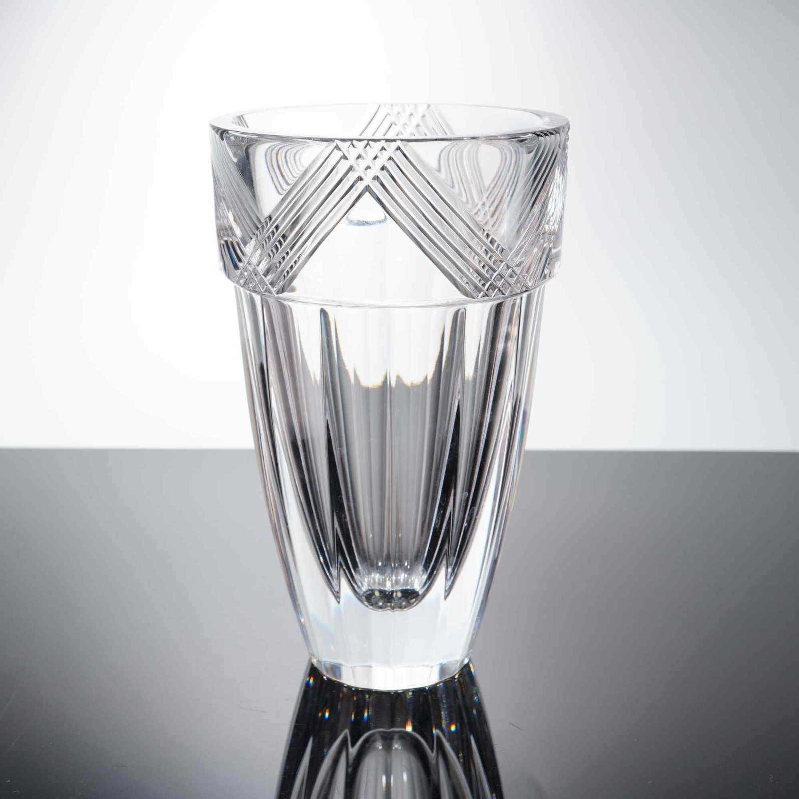 Orrefors Sweden Crystal Vase: The vase features a geometric cut pattern at the rim with vertical fluting extending down the body. Constructed of Swedish crystal. Suitable for use as a decorative vessel or for floral arrangements. 